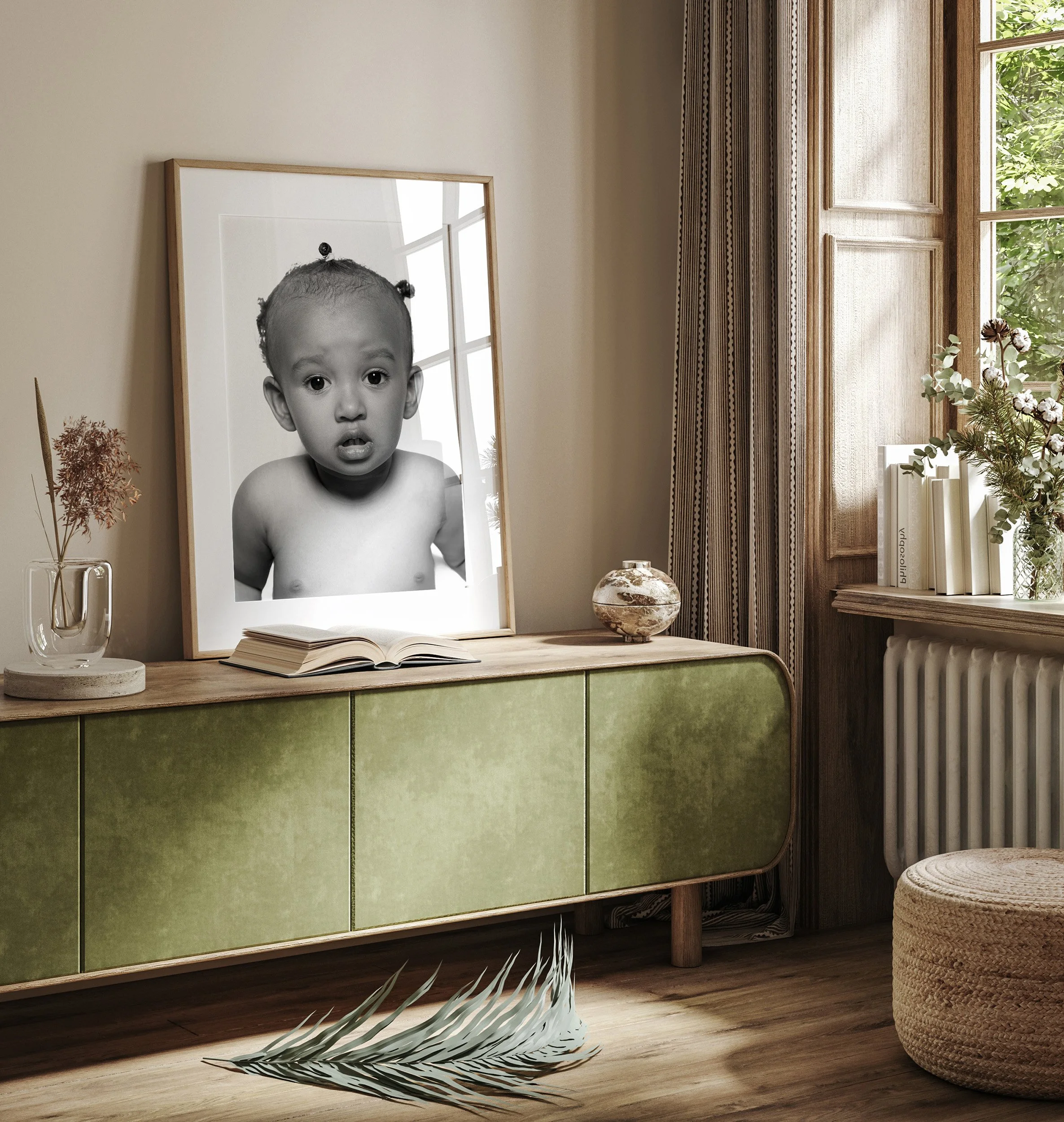 A black-and-white photograph of a young child with a surprised expression on their face, displayed on a mirror leaning against a wall on a wooden cabinet. The scene is set in a cozy room with a window, books, and decorative items.