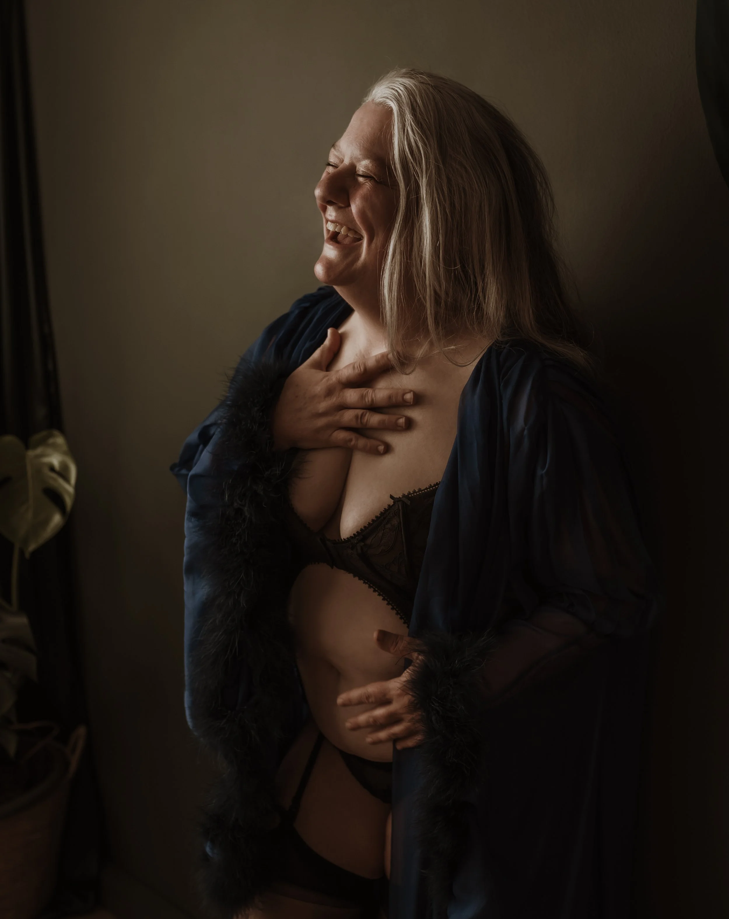 Woman aged 54 laughing during her boudoir photography session at Marieke Captures studio in Glasgow — empowerment photography Scotland