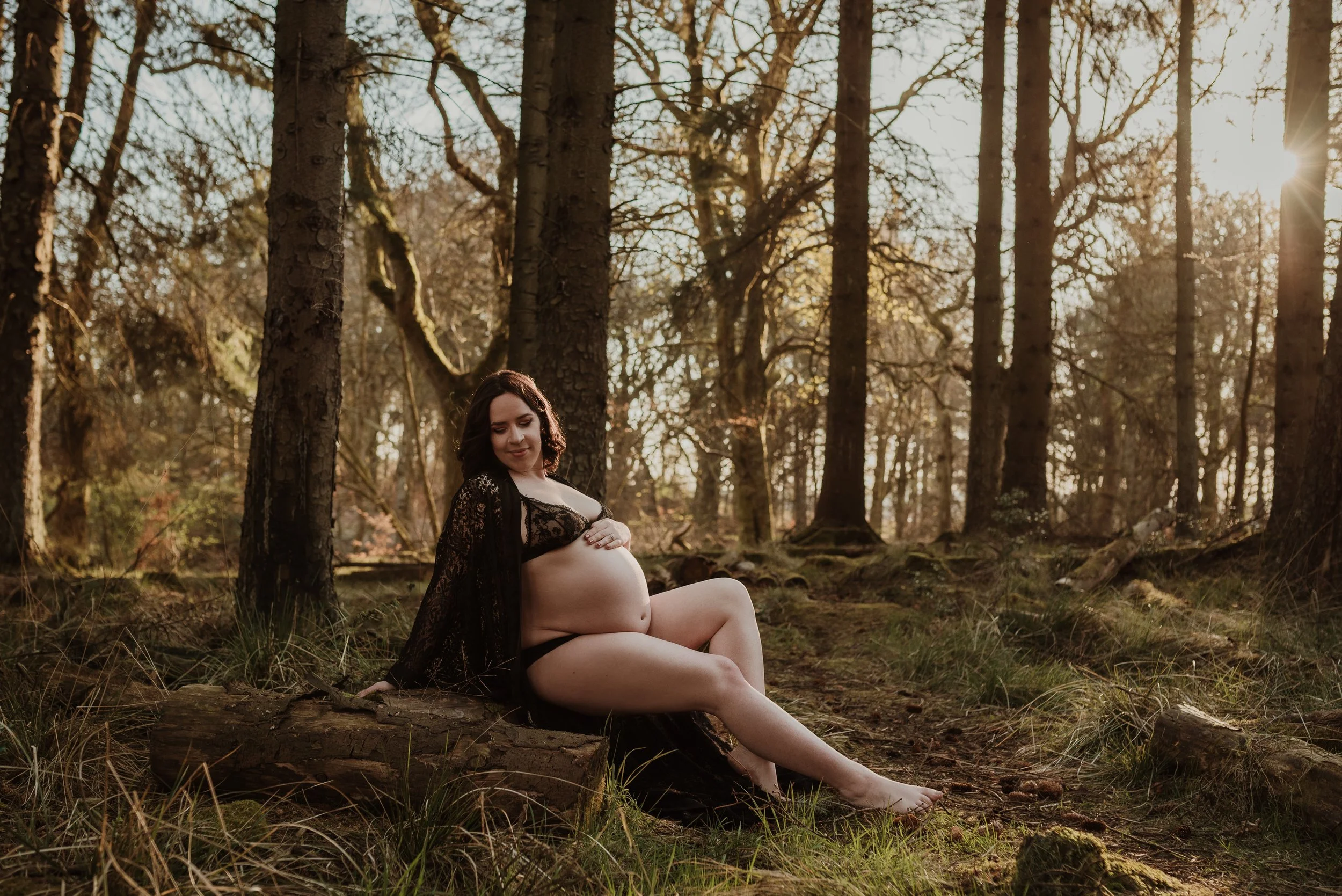 Maternity adventure boudoir photography Scotland — pregnant woman in woodland with golden sunlight through trees