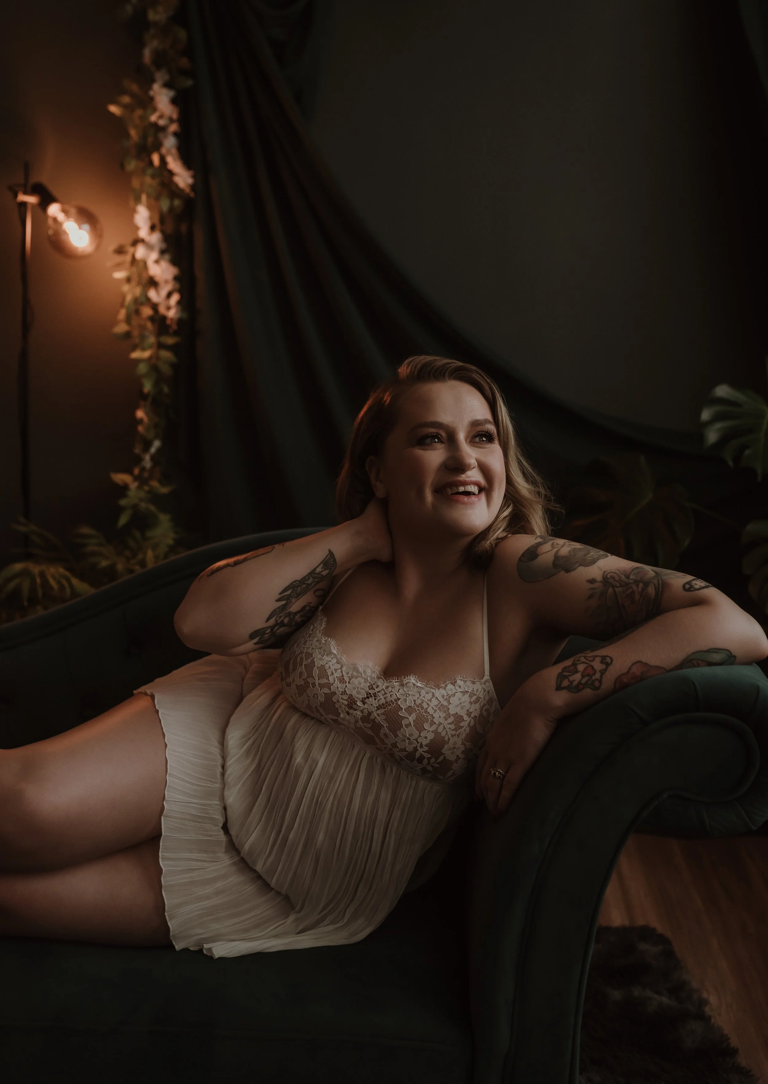 Woman laughing naturally during her first boudoir photography session at Marieke Captures studio in Glasgow, capturing a genuine moment of joy