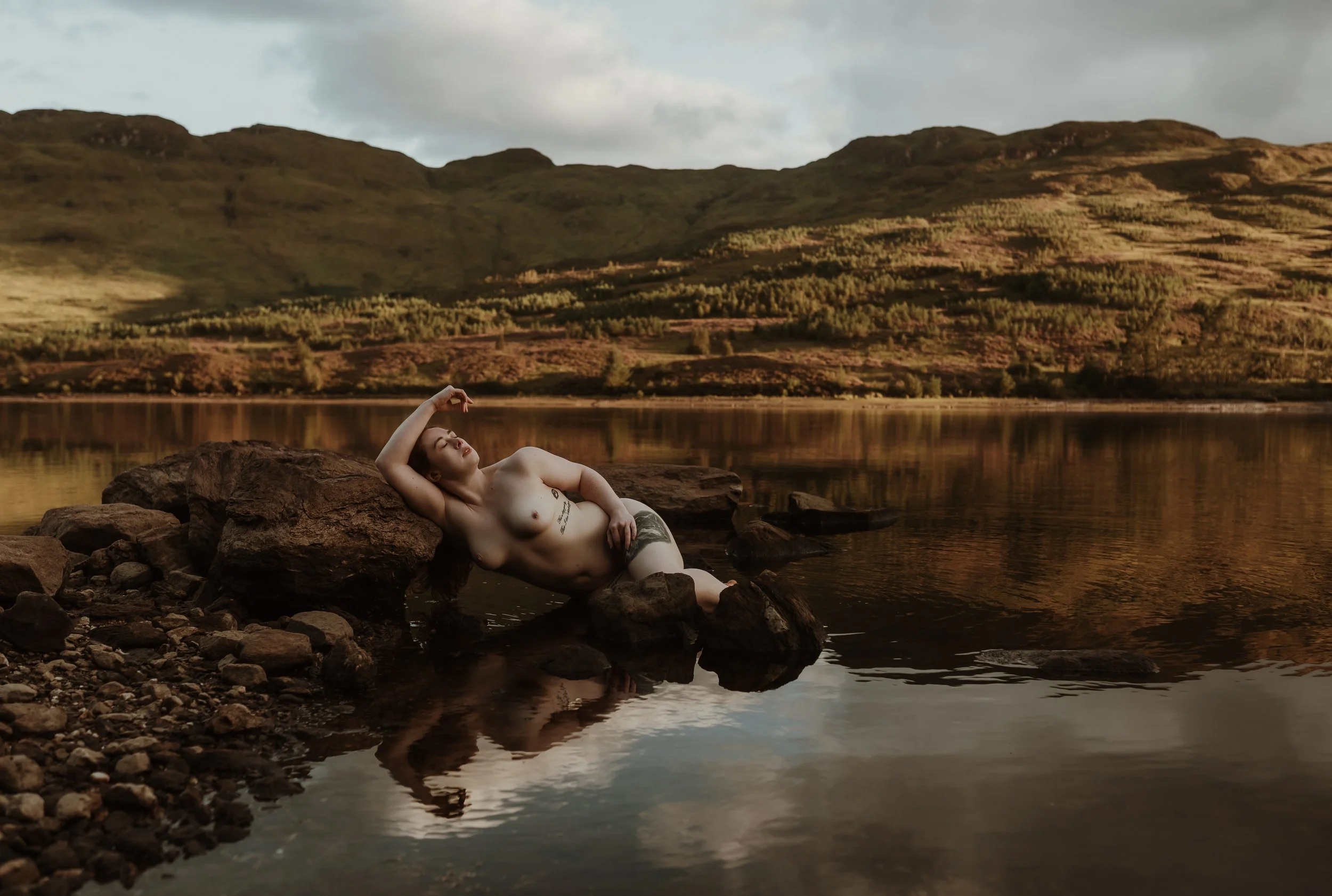 Woman in a loch in the Scottish Highlands during an outdoor adventure boudoir photography experience with Marieke Captures, Scotland