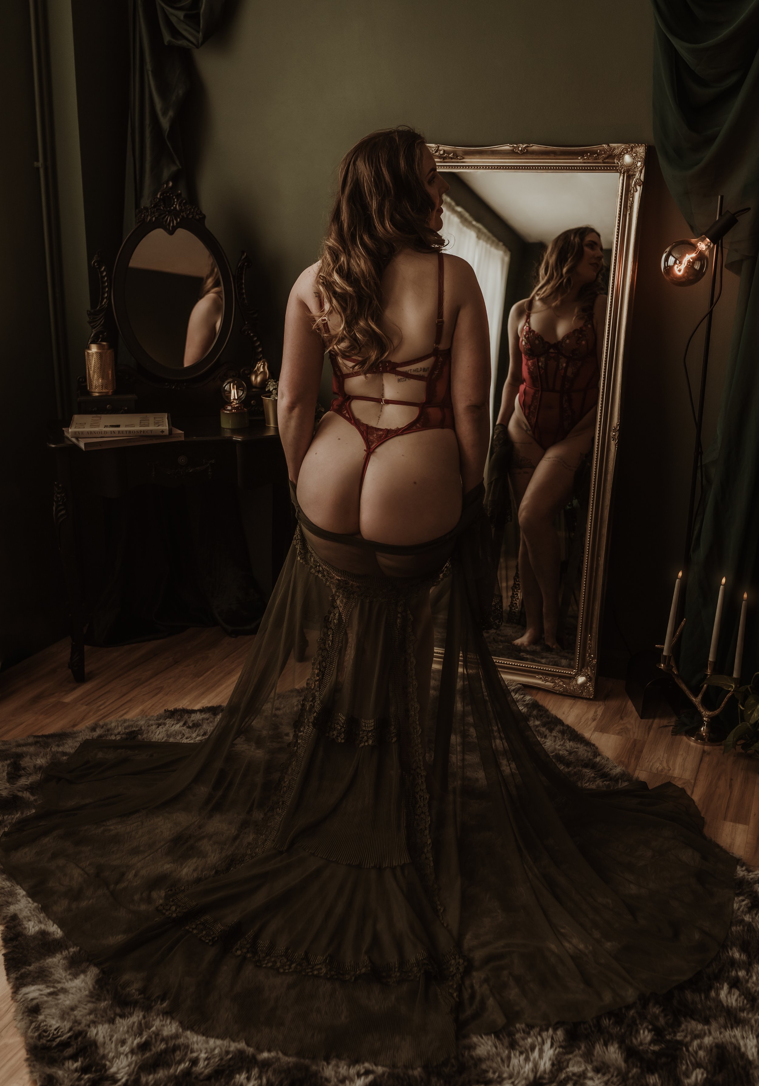Boudoir portrait of a client in red lingerie facing a gold mirror at Marieke Captures studio, Glasgow, the art of self-admiration