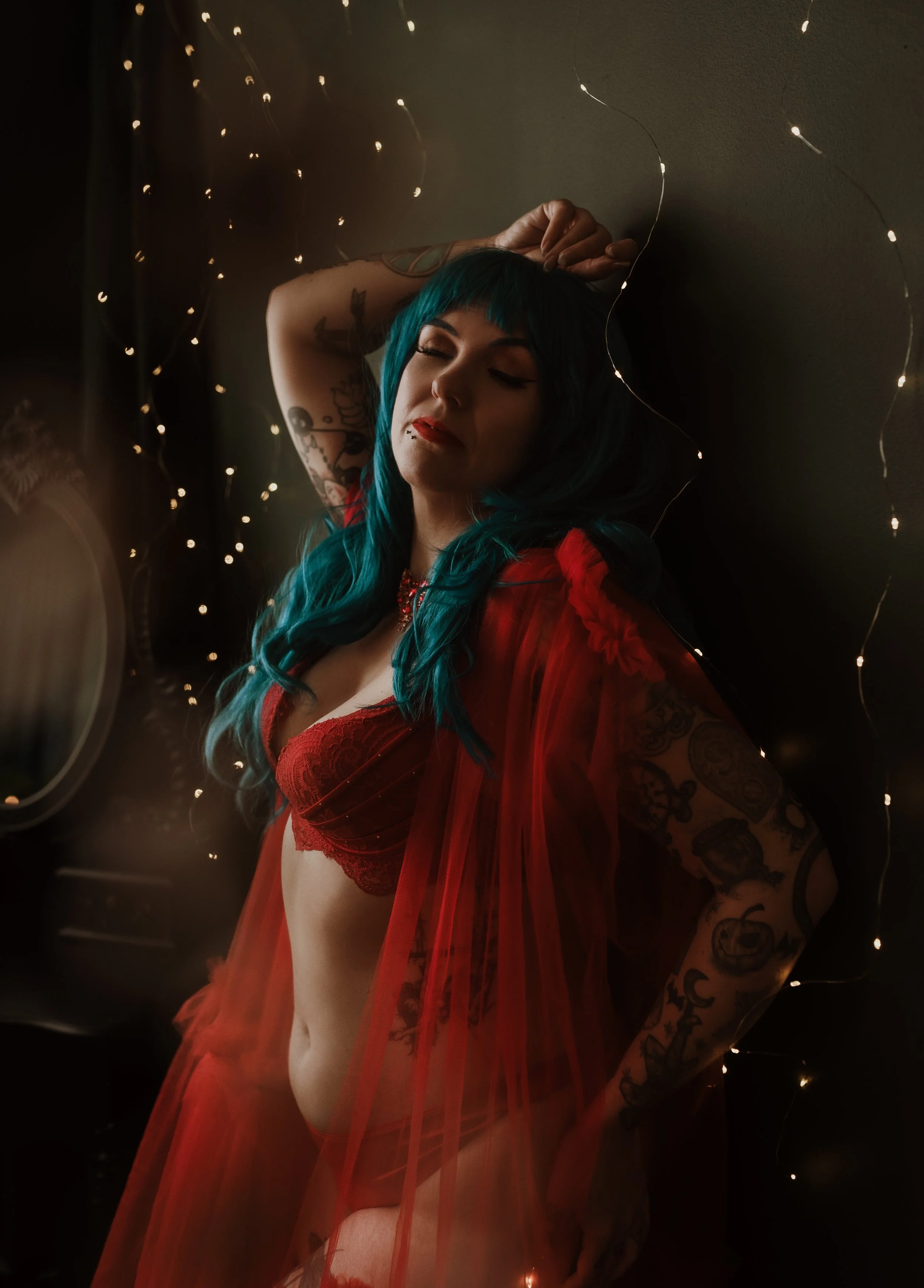 Christmas Boudoir Portrait	Christmas boudoir portrait of a client in red tulle with eyes closed, surrounded by fairy lights, Marieke Captures Glasgow