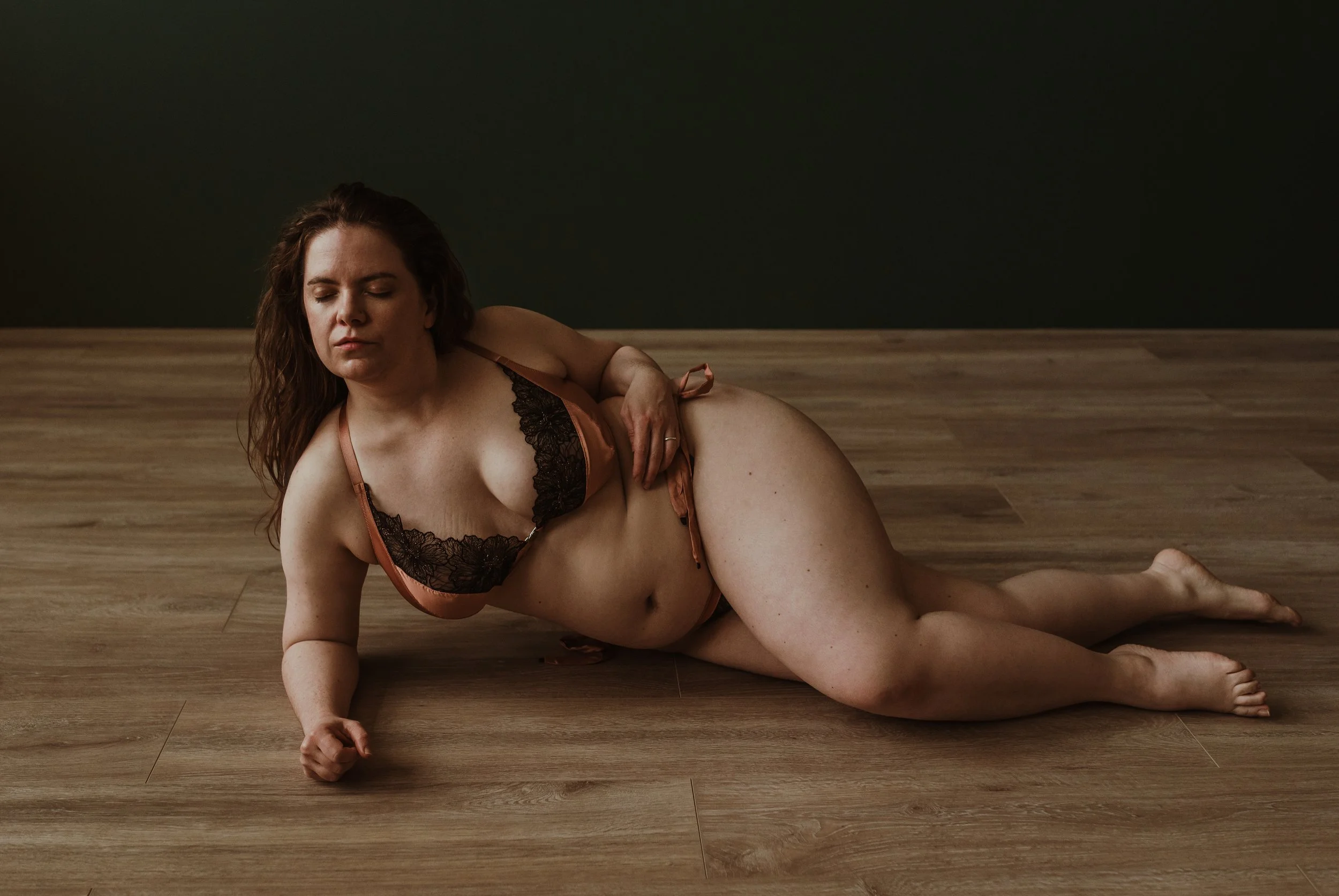Woman lying on her side with eyes closed during a boudoir photography session at Marieke Captures studio in Scotland — an intimate and softly lit portrait celebrating self-observation
