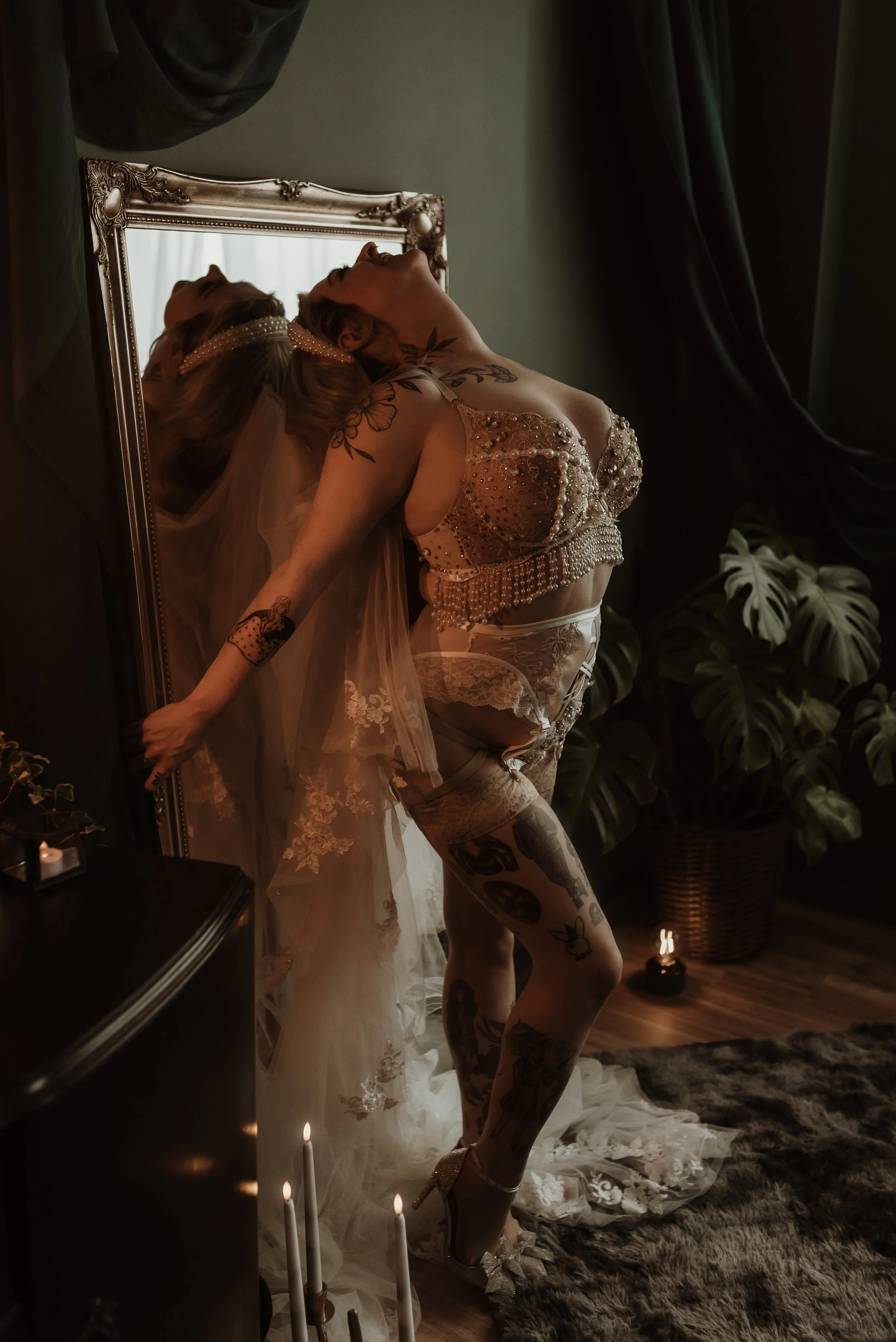 A softly lit wedding boudoir portrait of an engaged person sitting comfortably, wearing relaxed neutral tones and looking confident and at ease. The image reflects self-acceptance and confidence without pressure to change before the wedding day.