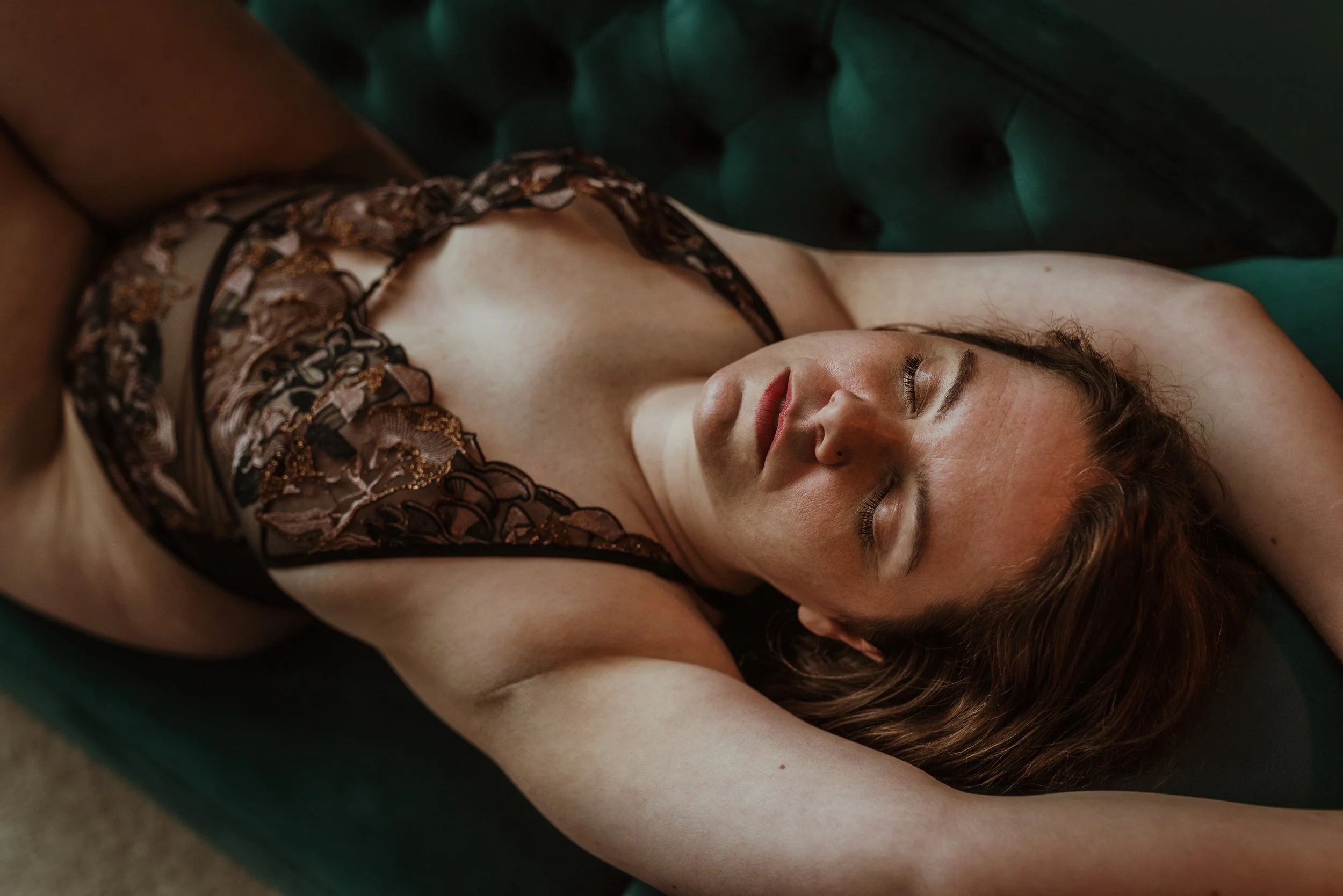Woman lying on a chaise longue with eyes closed during a body confidence boudoir photography session at Marieke Captures studio in Glasgow, Scotland — a moment of quiet self-acceptance