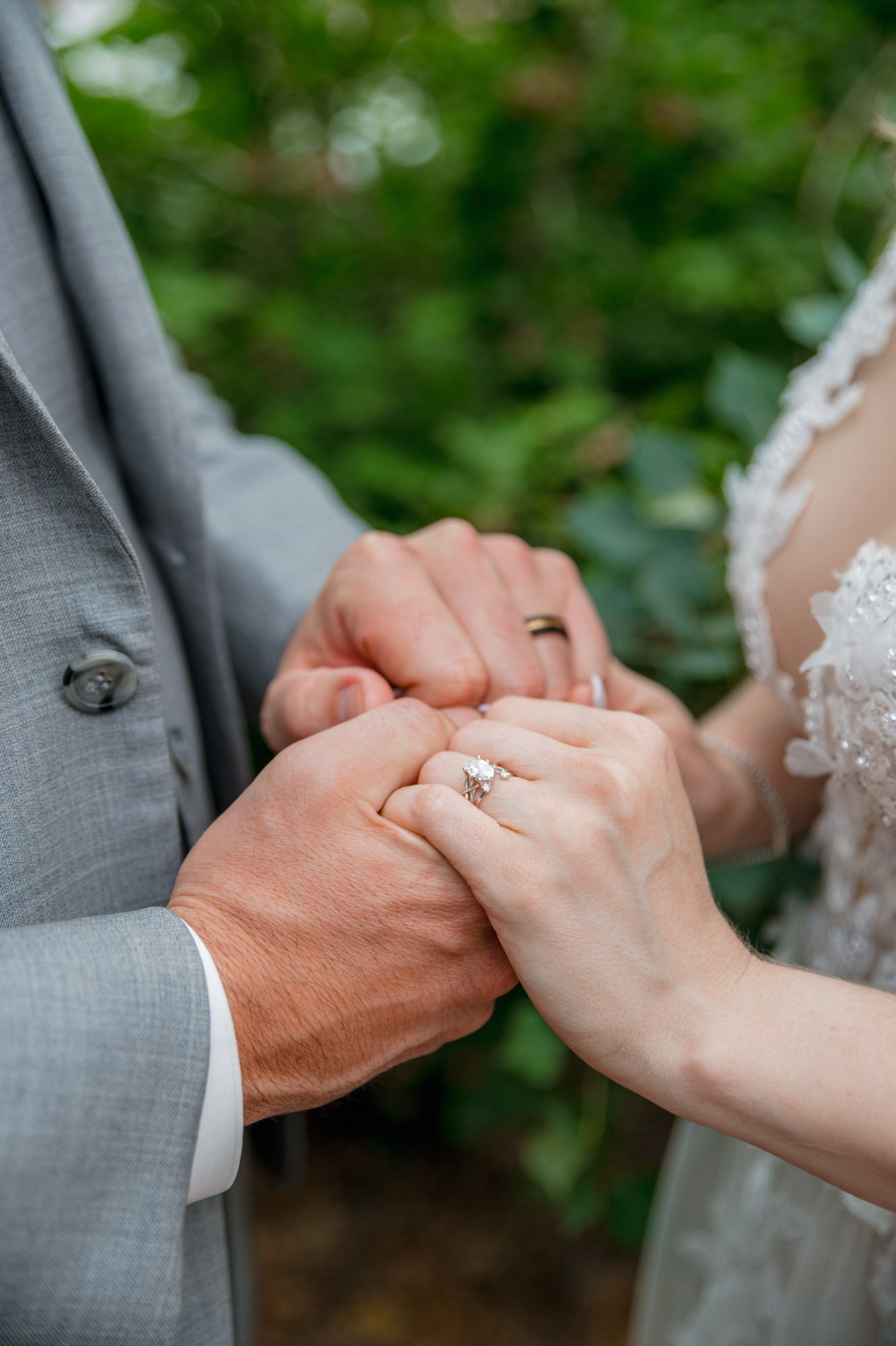 bride and groom holding hands displaying their rings