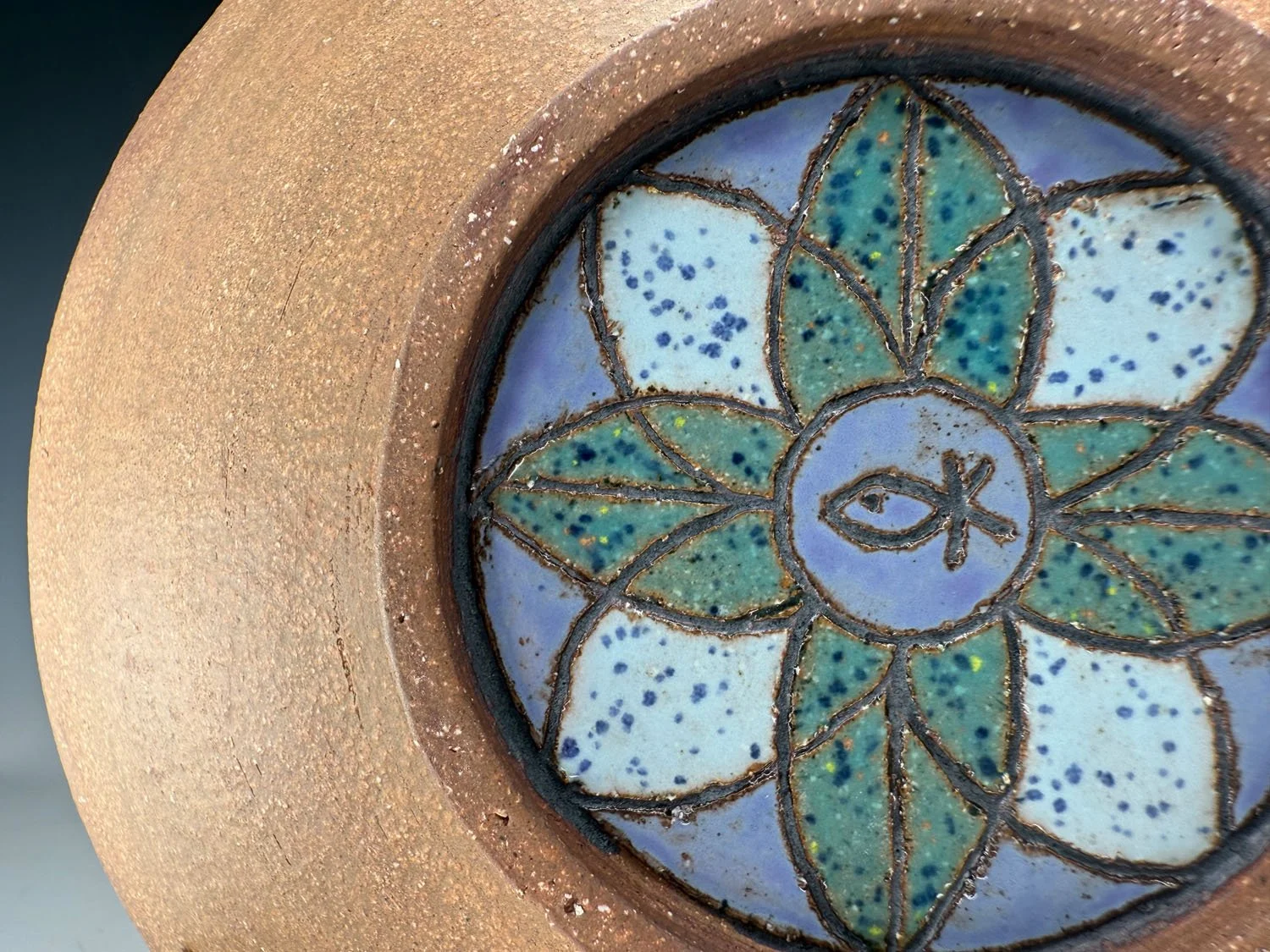 Closeup view of Blue green carved red stoneware serving bowl