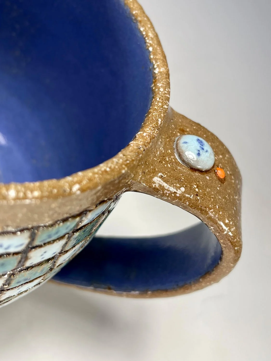 Handle details on Carved blue green tiles stoneware mug
