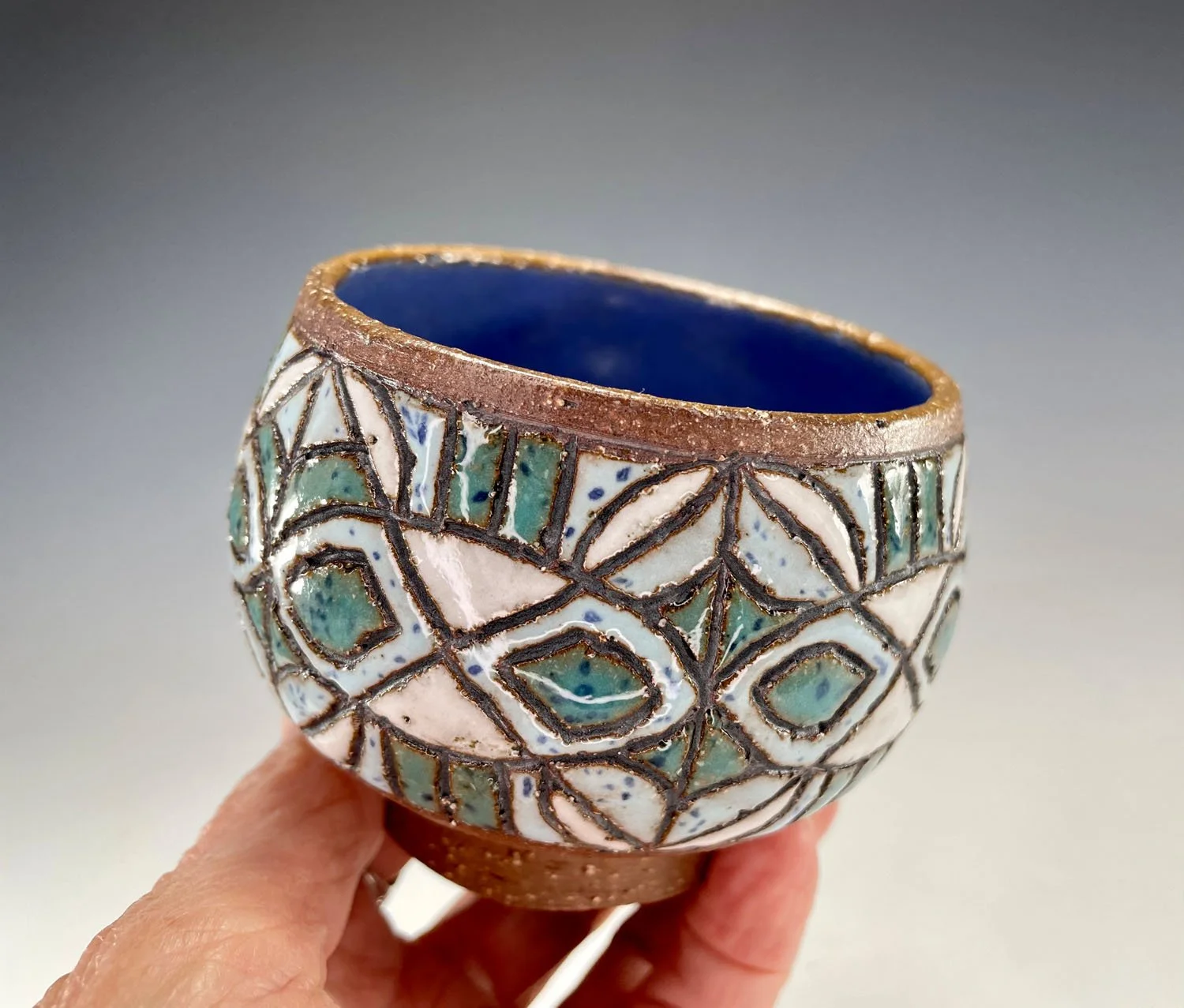 Hand holding Carved stoneware cup bowl