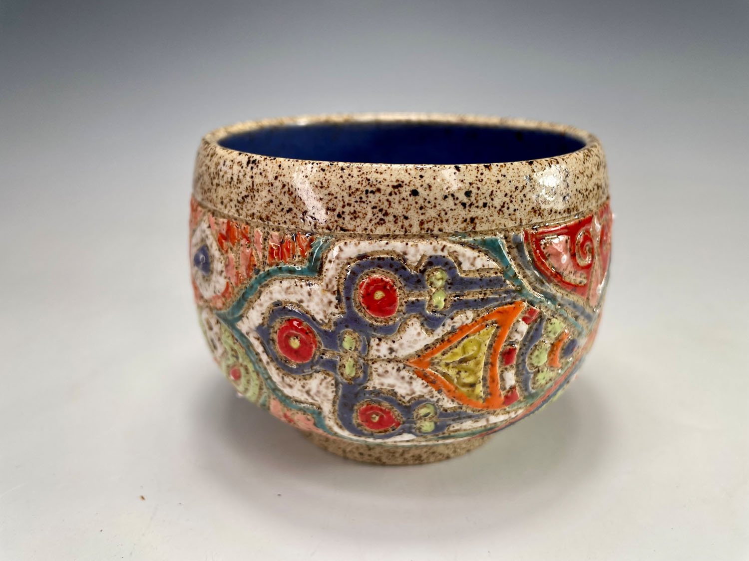 Colorful designs side 1 on stoneware tea bowl