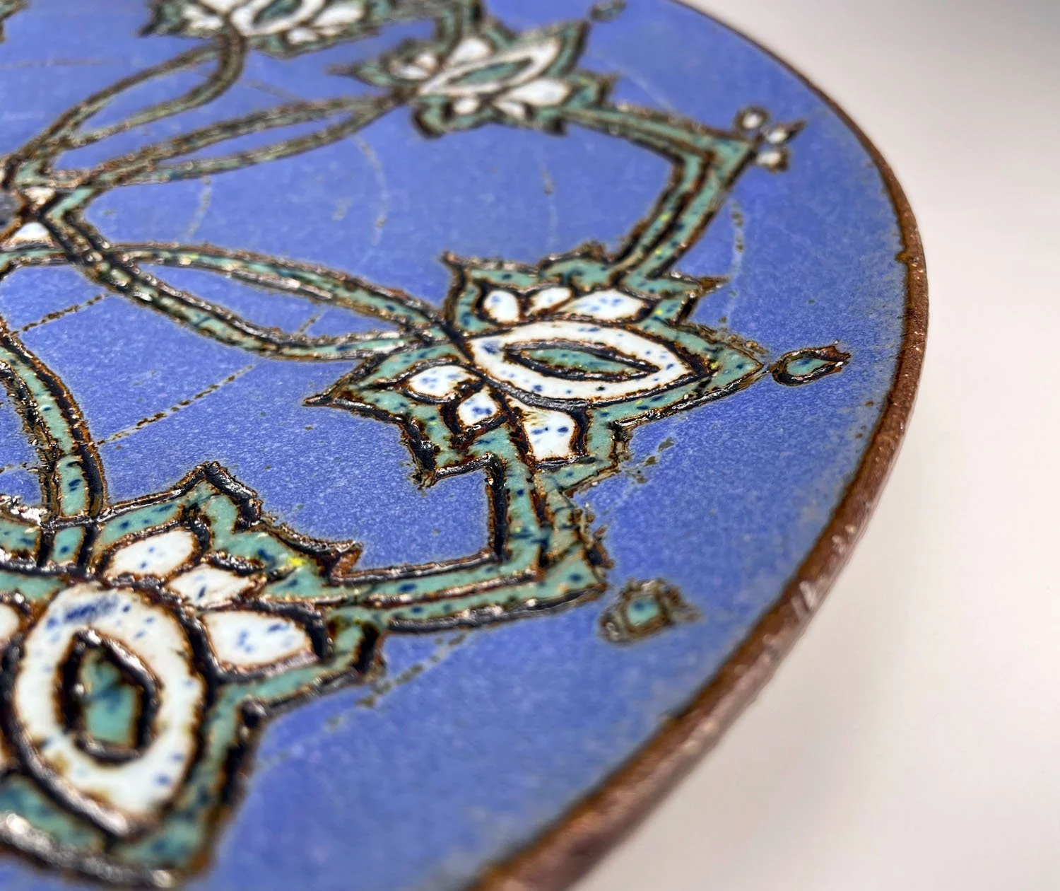 Closeup view of design on Periwinkle blue hand carved stoneware plate