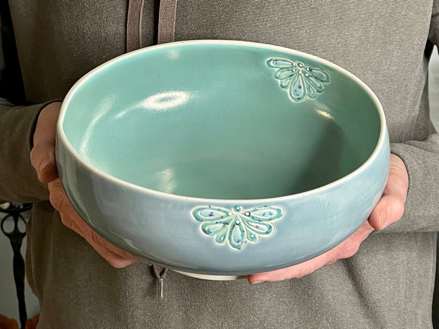 Hands holding Water blossom carved porcelain serving bowl