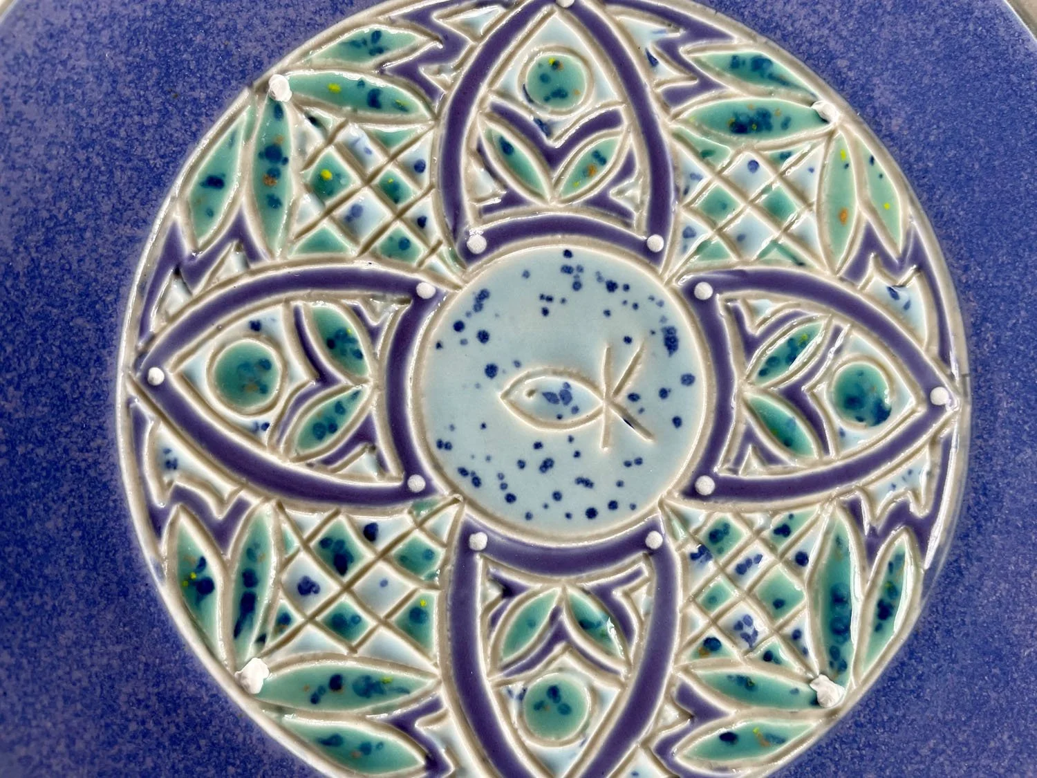Closeup of back design of Hand carved blue porcelain platter plate with blue green design