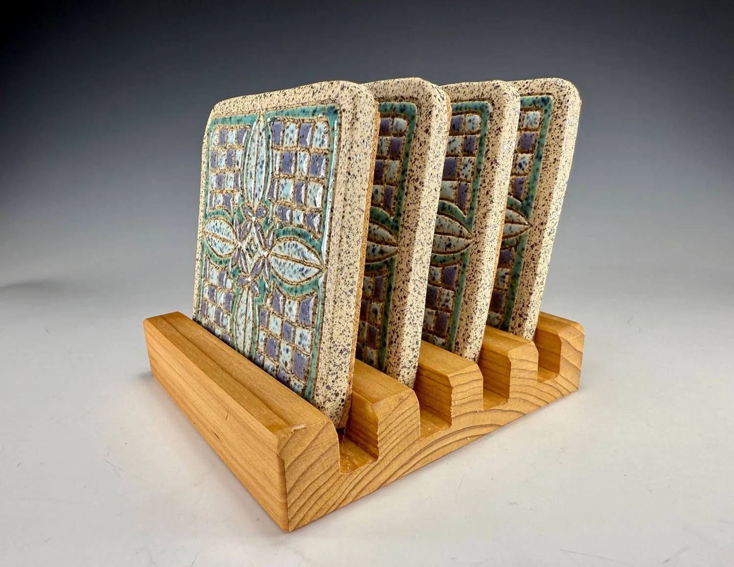 Side view of Hand carved stoneware coasters w stand