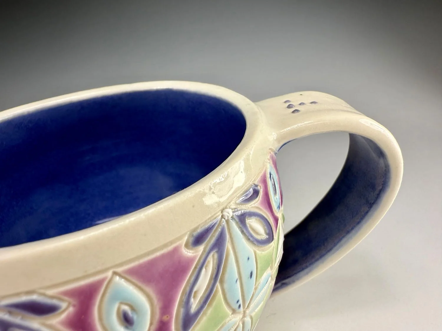 Handle closeup of Purple blue carved porcelain mug