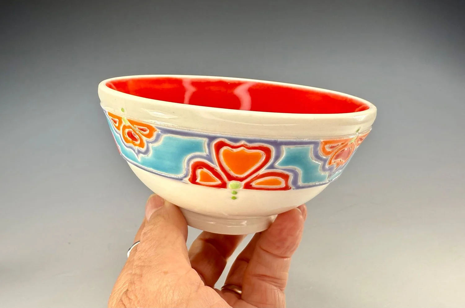 Hand holding Bowl 1 of Red porcelain snack bowl set