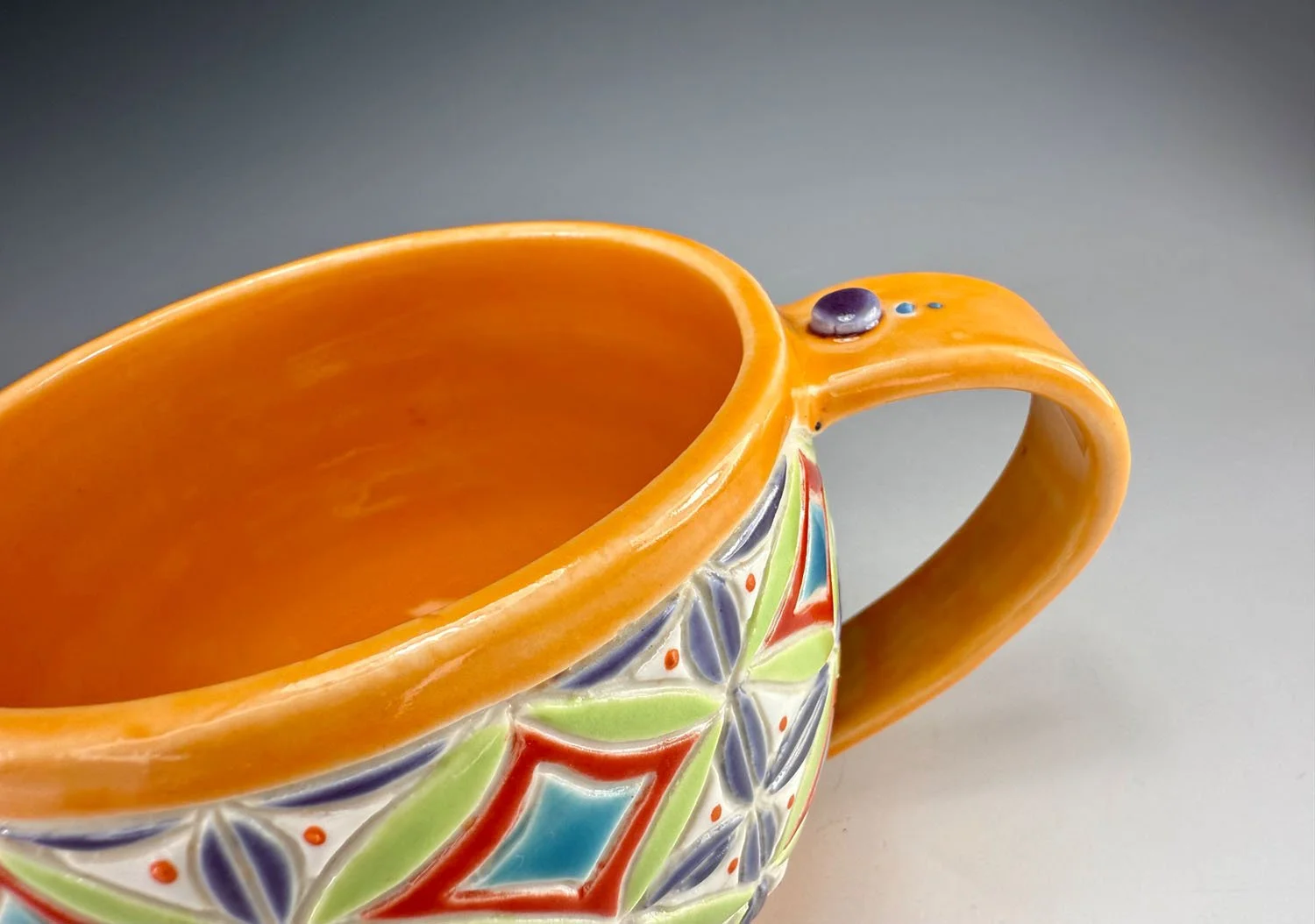 Interior view of Orange carved porcelain mug