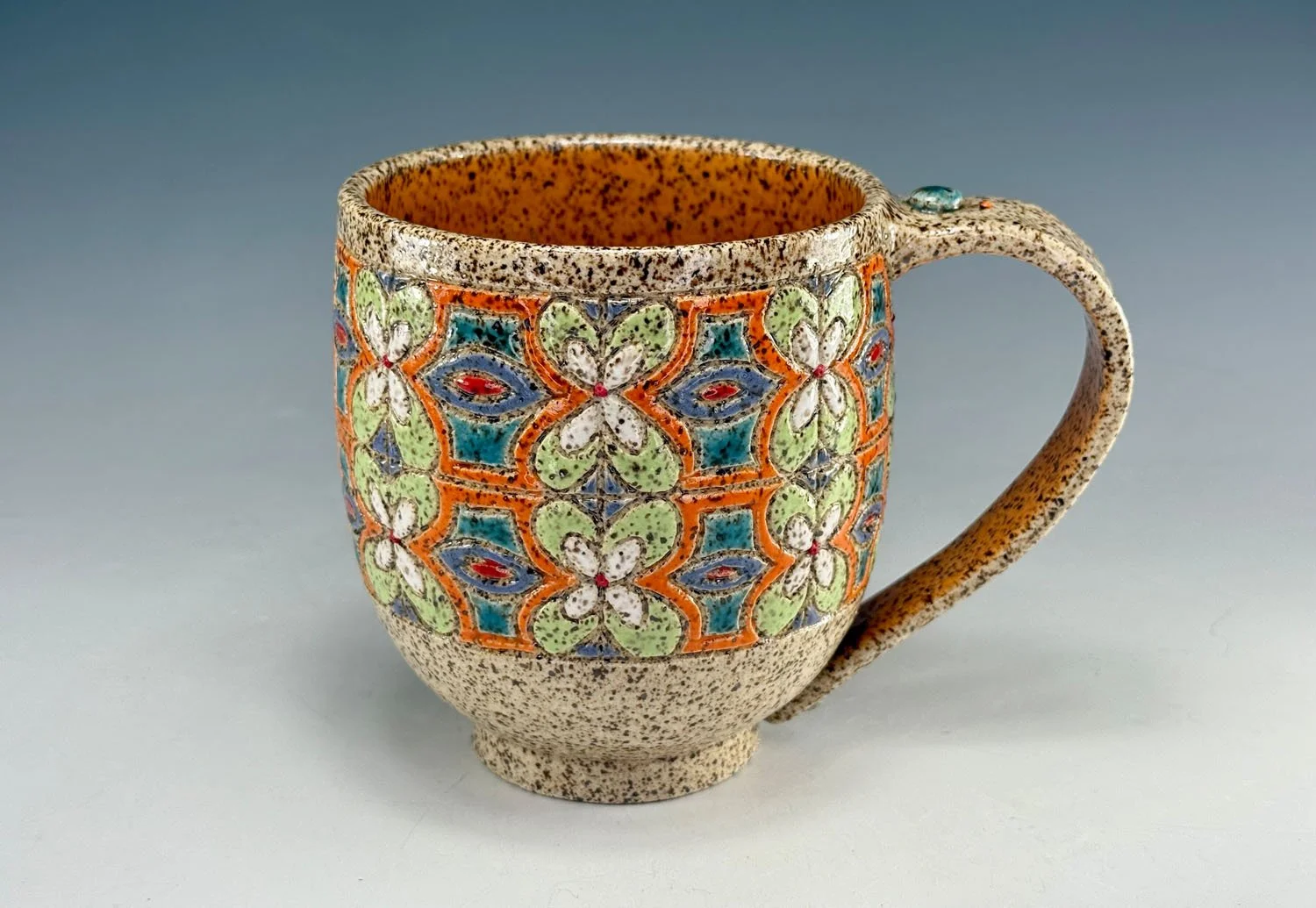 Colorful carved stoneware mug