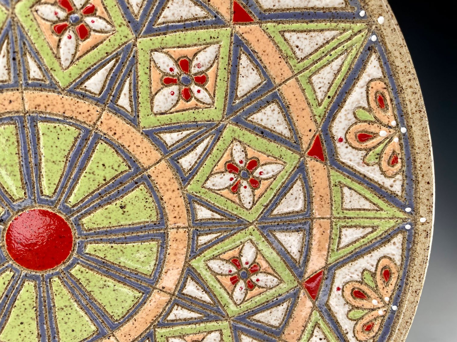Closeup of front design on Intricately carved stoneware serving plate