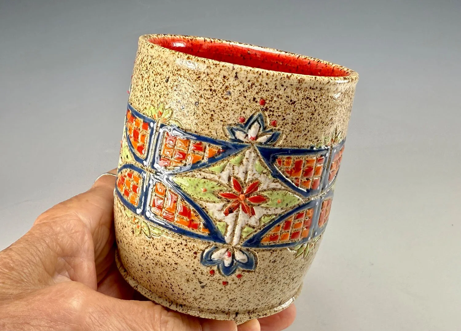 Hand holding Carved stoneware tumbler
