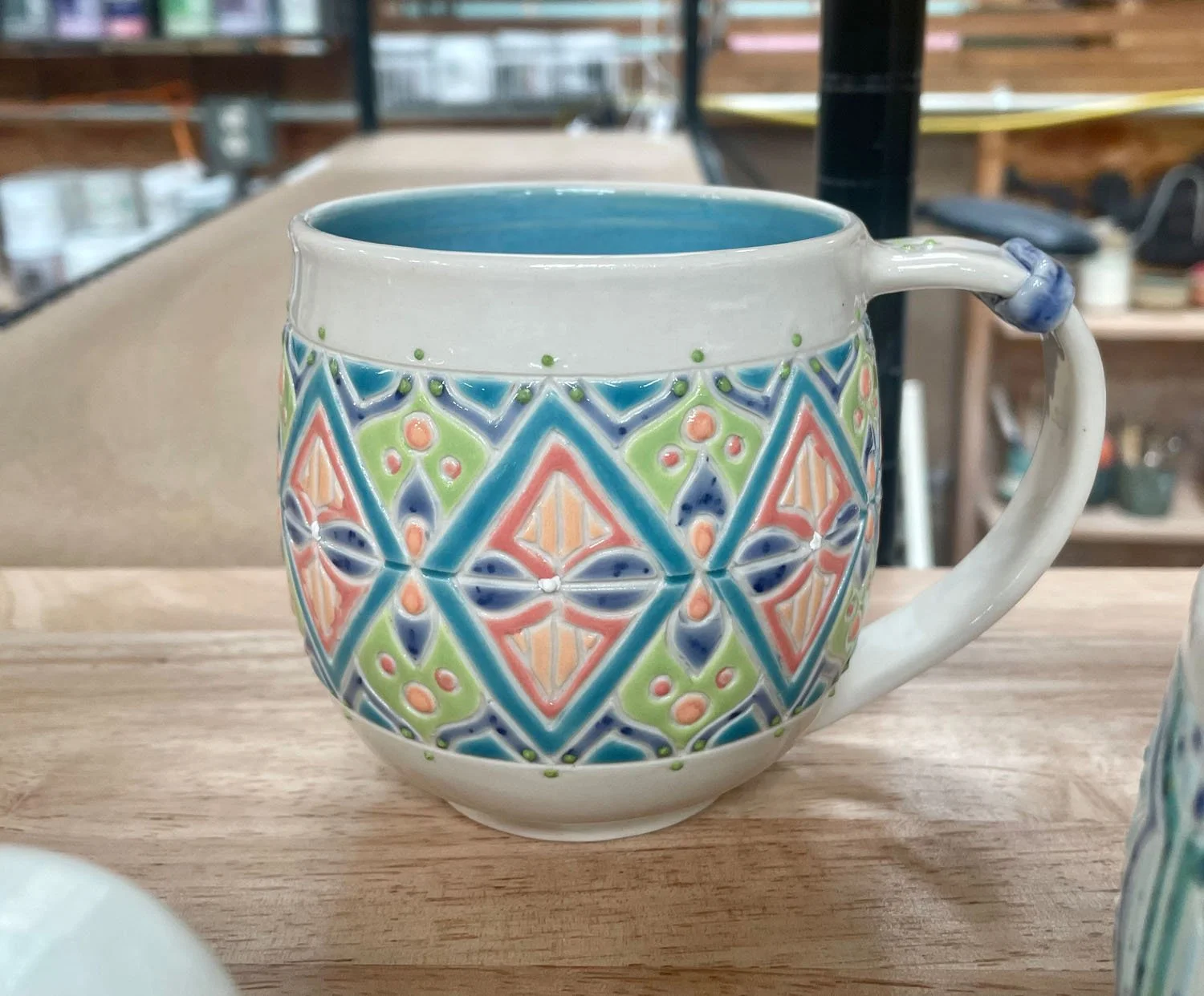 Shelf placement of Candy colored carved porcelain mug