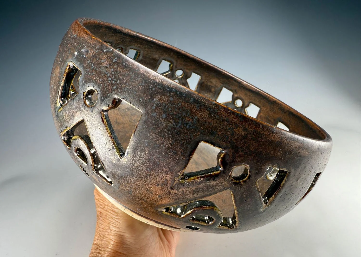 Hand holding Cutout bronze stoneware bowl