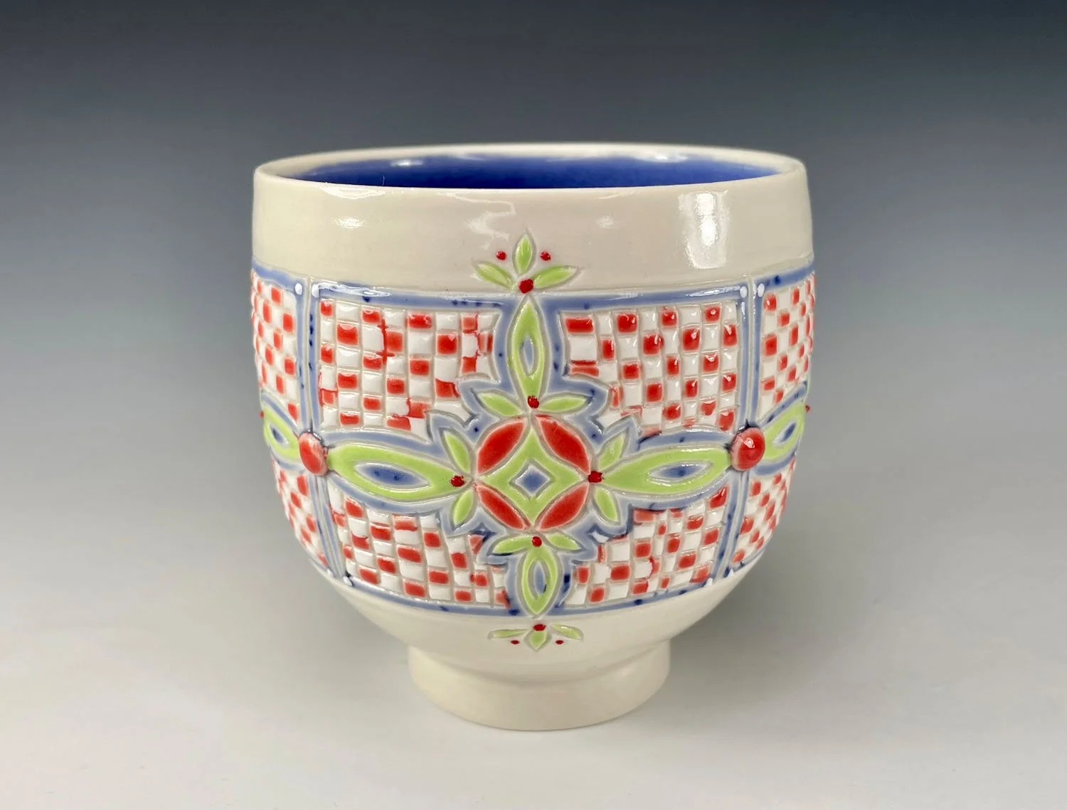 Twelve ounce porcelain wine cup with unique checkerboard design and periwinkle liner