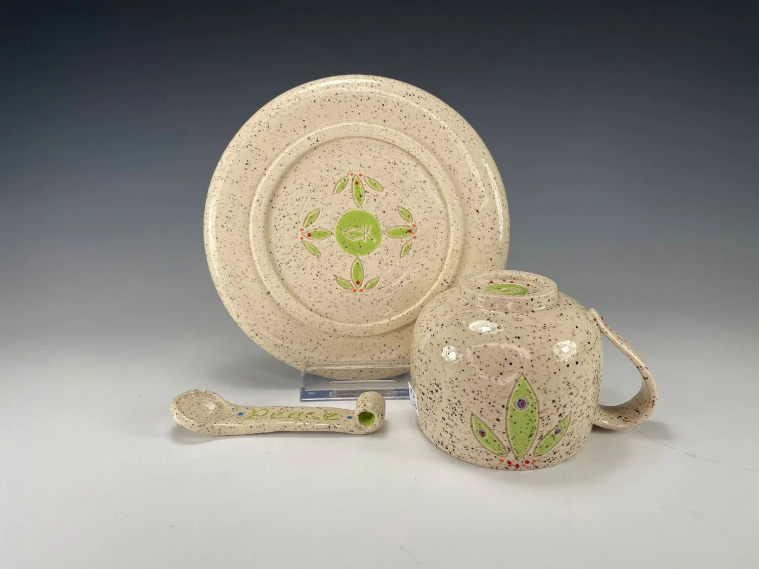Back view of Peace cup saucer spoon stoneware set