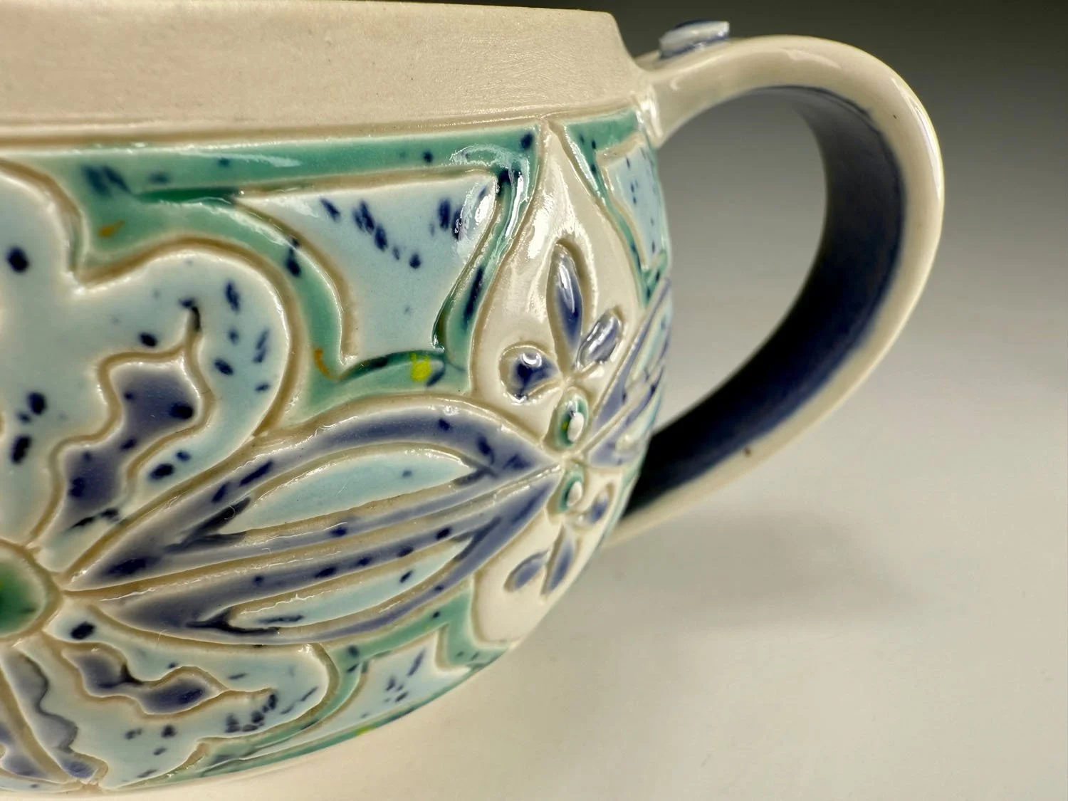 Closeup of Carved Blue Green Porcelain Mug