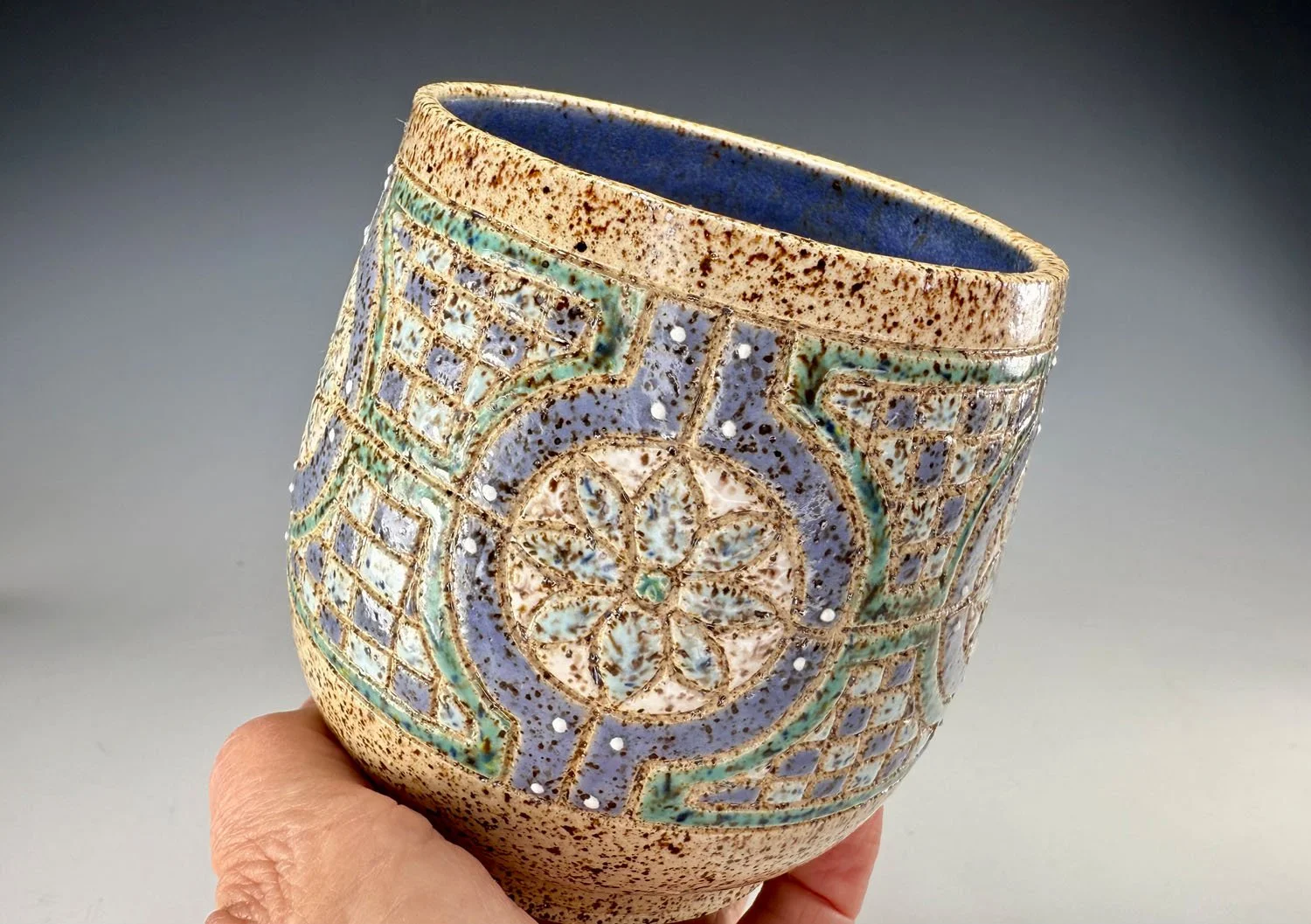 hand holding Blue green stoneware bowl handleless mug