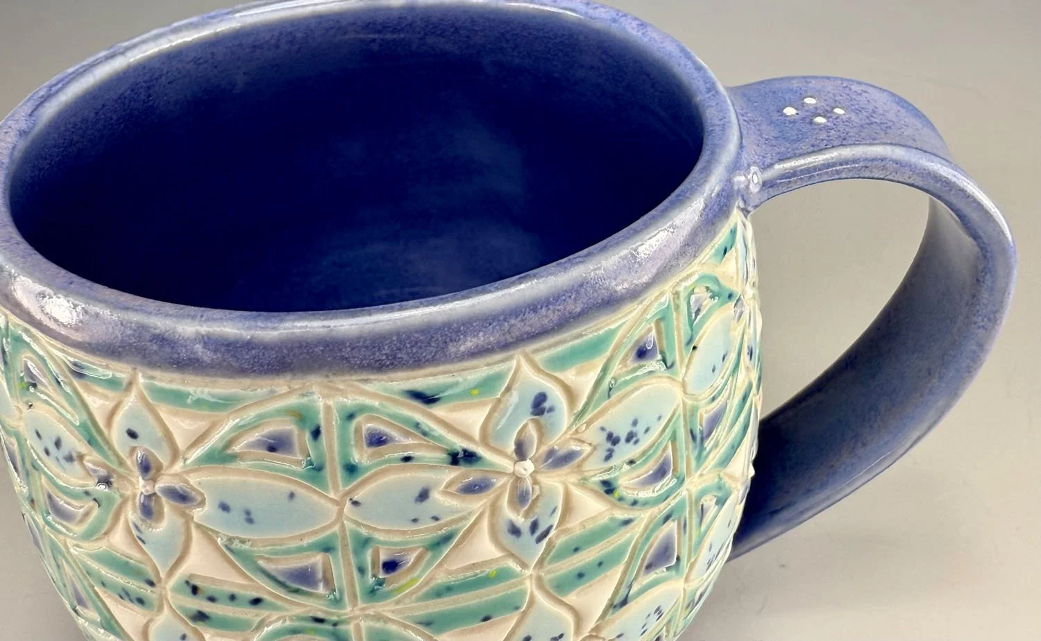 Handle closeup of Misty blue carved porcelain mug