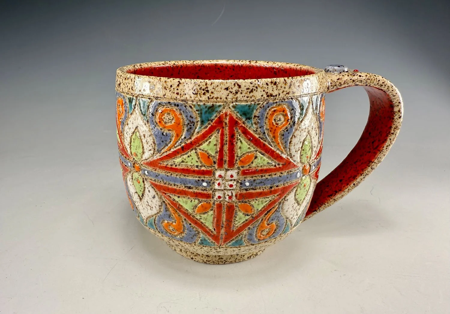 Colorful carved stoneware mug