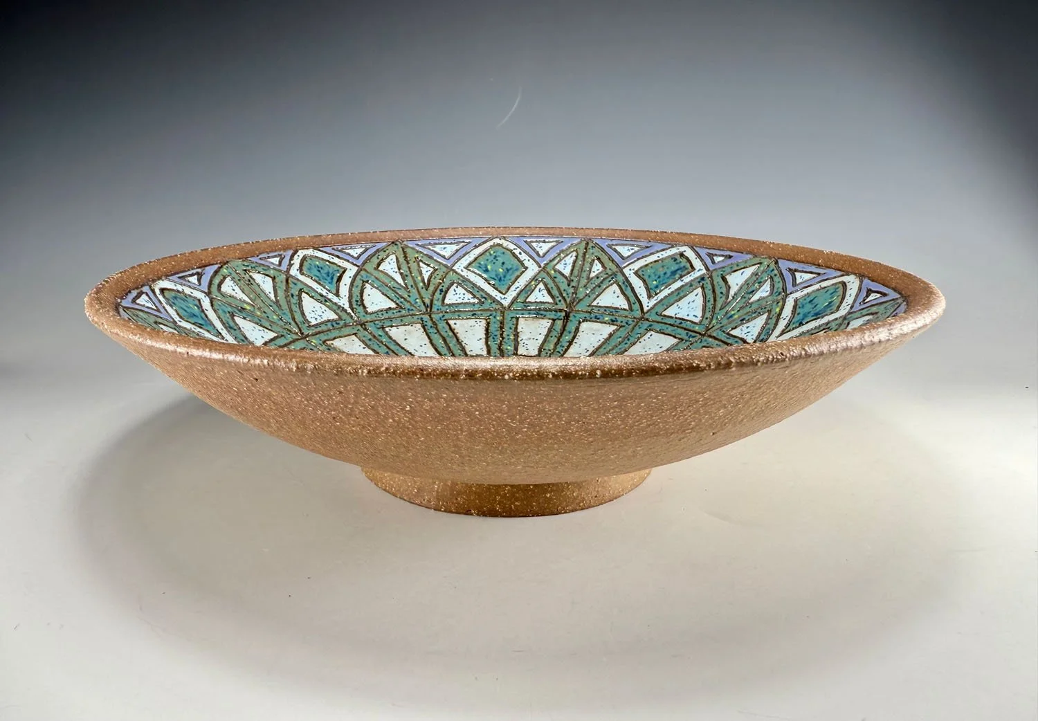 Side view od Blue green carved red stoneware serving bowl