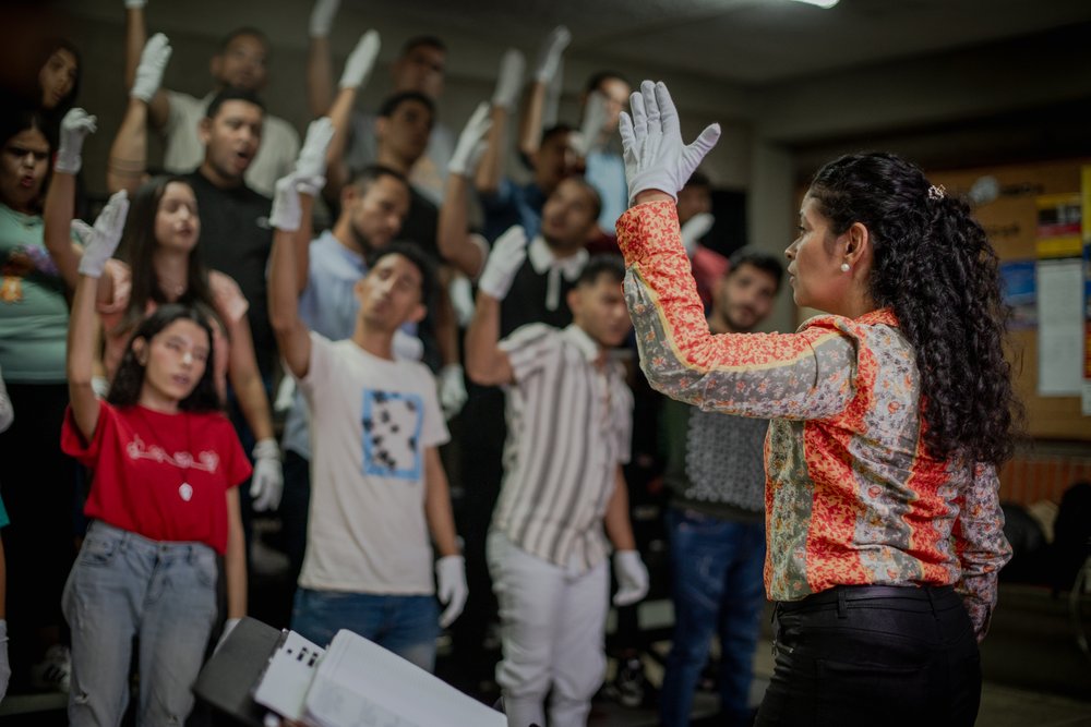Assistant Director María Estefanía Prieto and members of the Deaf section of the White Hands Choir (El Coro de Manos Blancas) rehearse in Barquisimeto, Venezuela. February 2024.