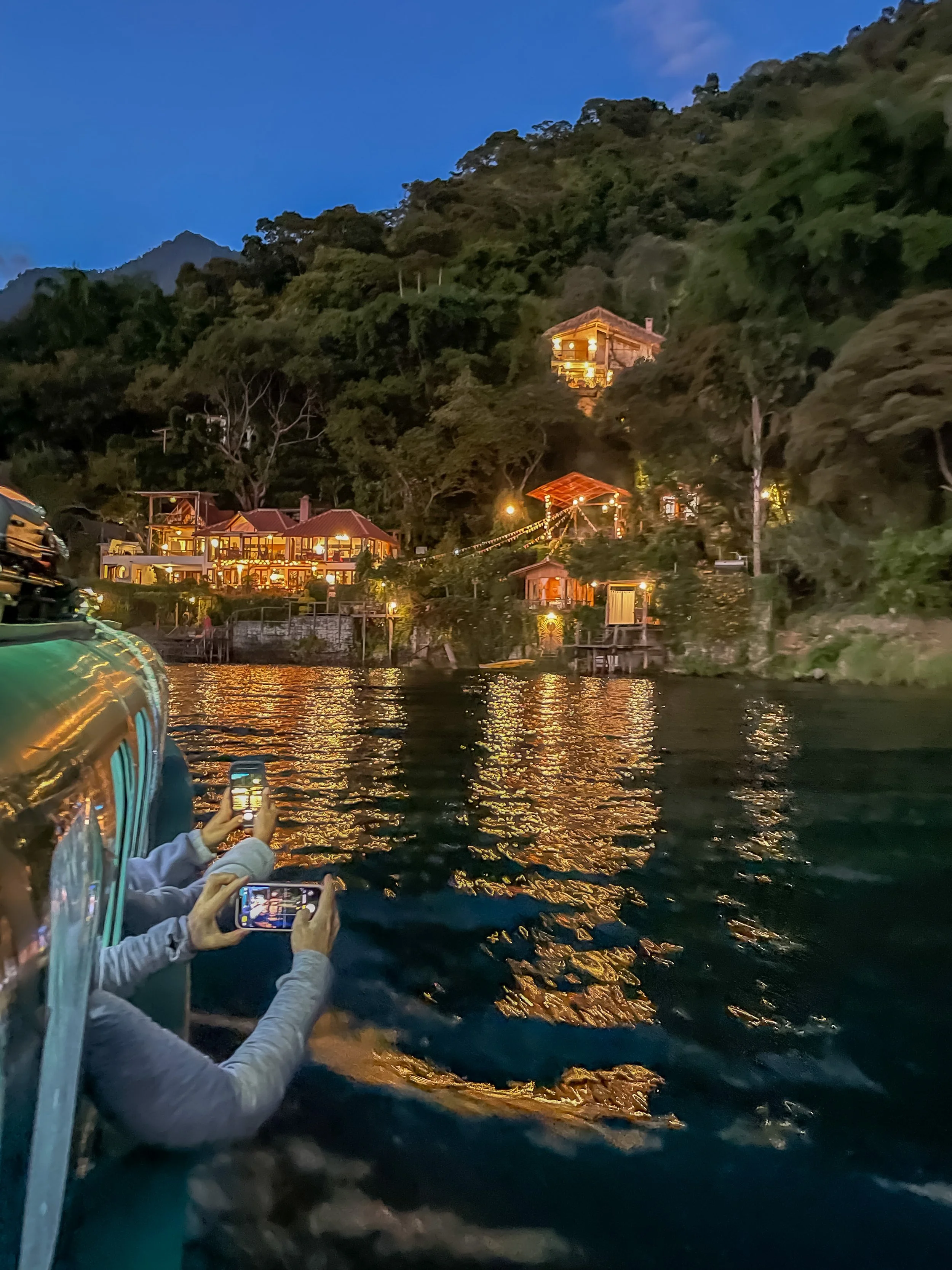 Night view from a lancha looking at illuminated Casa Paloma on Lake Atitlan.