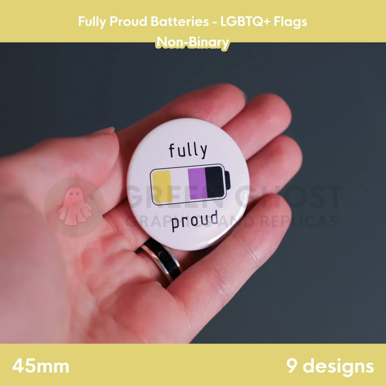 A round badge with a yellow, white, purple, and black battery design held in a hand.