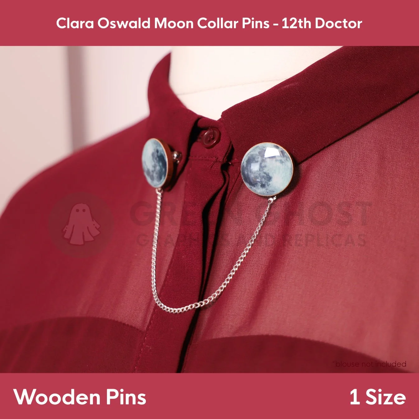 Two circular moon‑themed wooden pins connected by a fine chain clipped to the collar points of a maroon blouse.