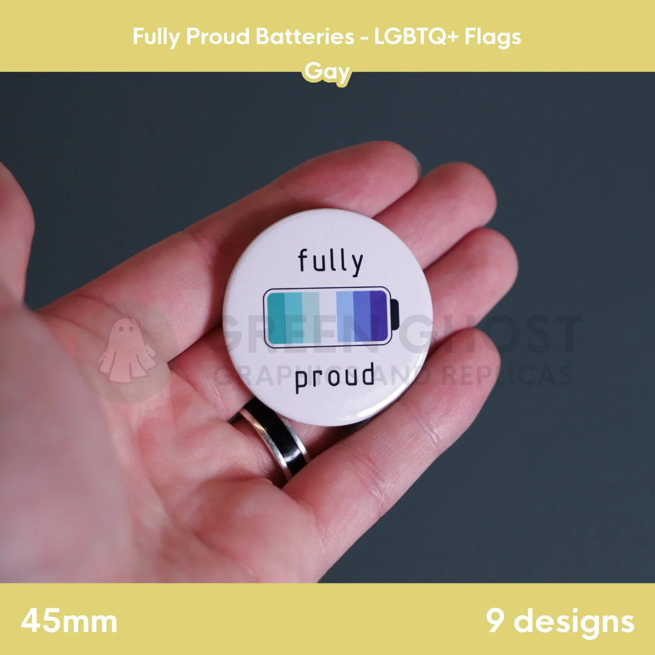 A round badge with teal, blue, and purple battery stripes held in a hand against a grey background.