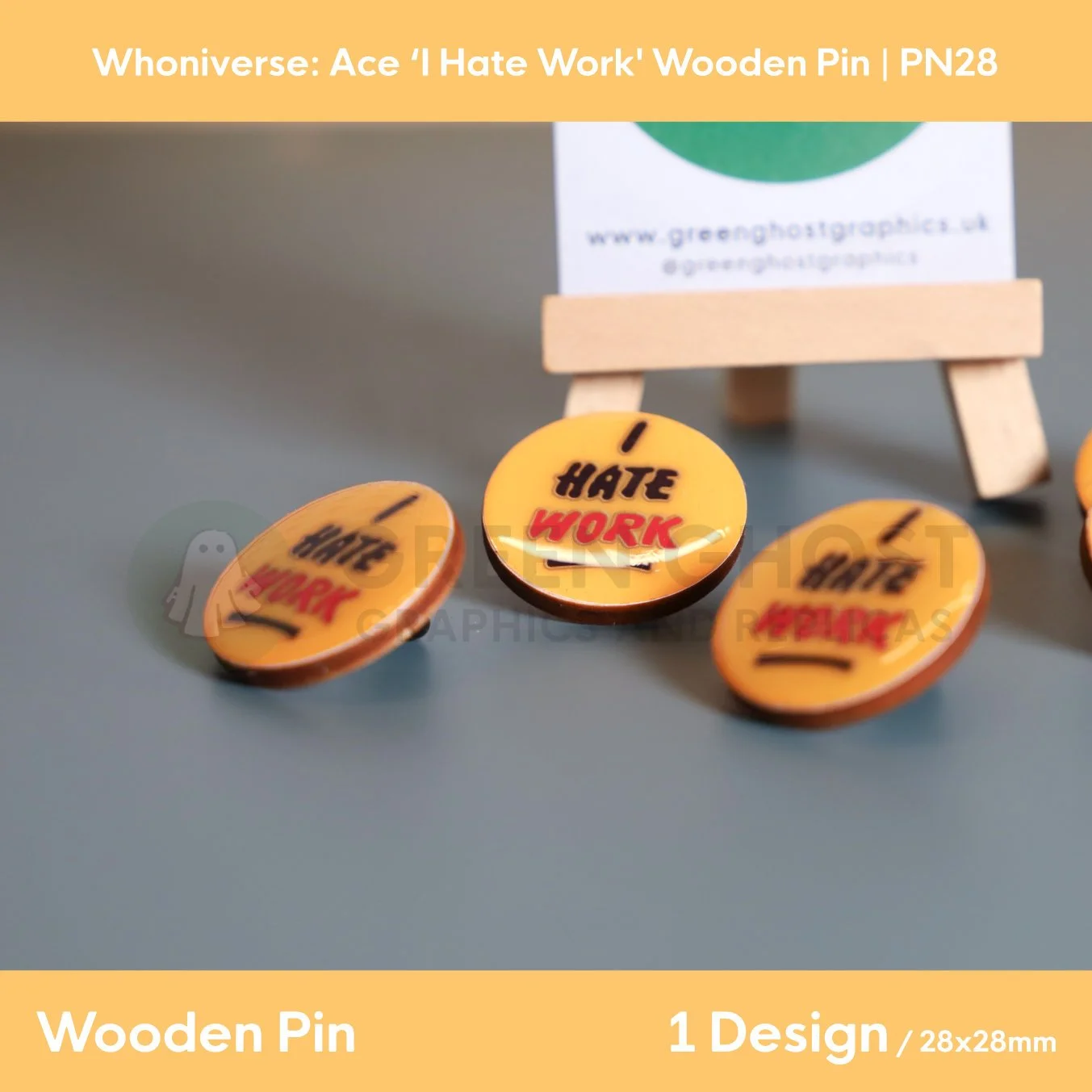 A close up shot of the yellow circular “I HATE WORK” wooden pin with black and red text on a wooden easel.