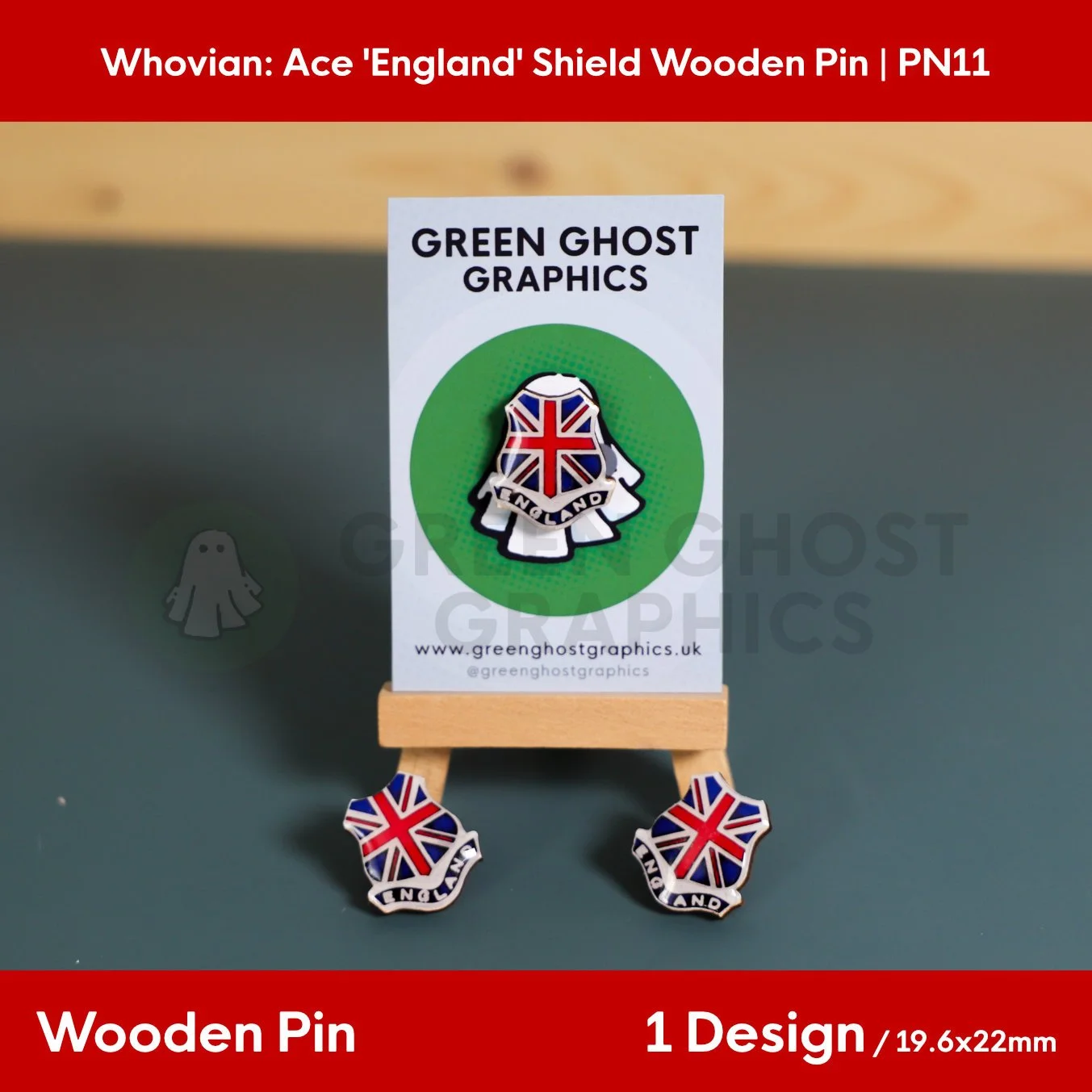 Three shield‑shaped wooden pins featuring a Union Jack pattern and the word “ENGLAND” arranged around a branded display card on a small wooden easel.