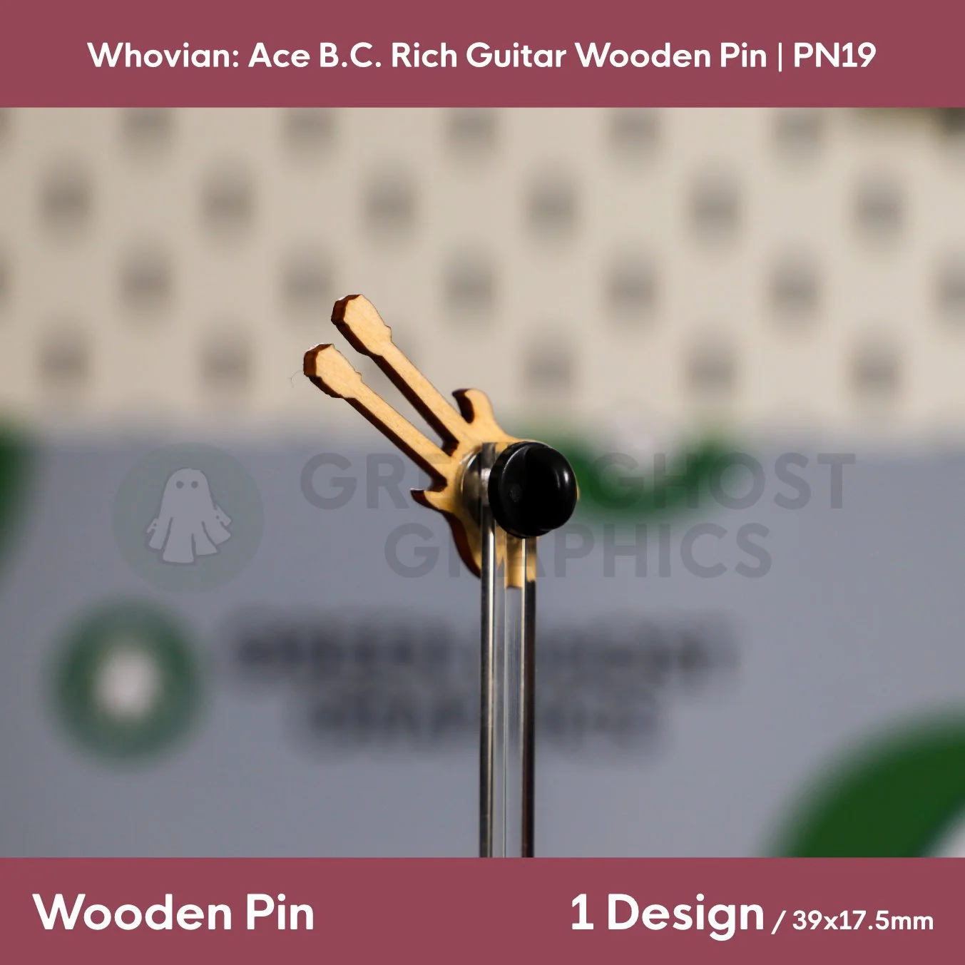 The back of a double‑neck guitar‑shaped wooden pin with a natural wood finish and black rubber clasp displayed on a clear stand.