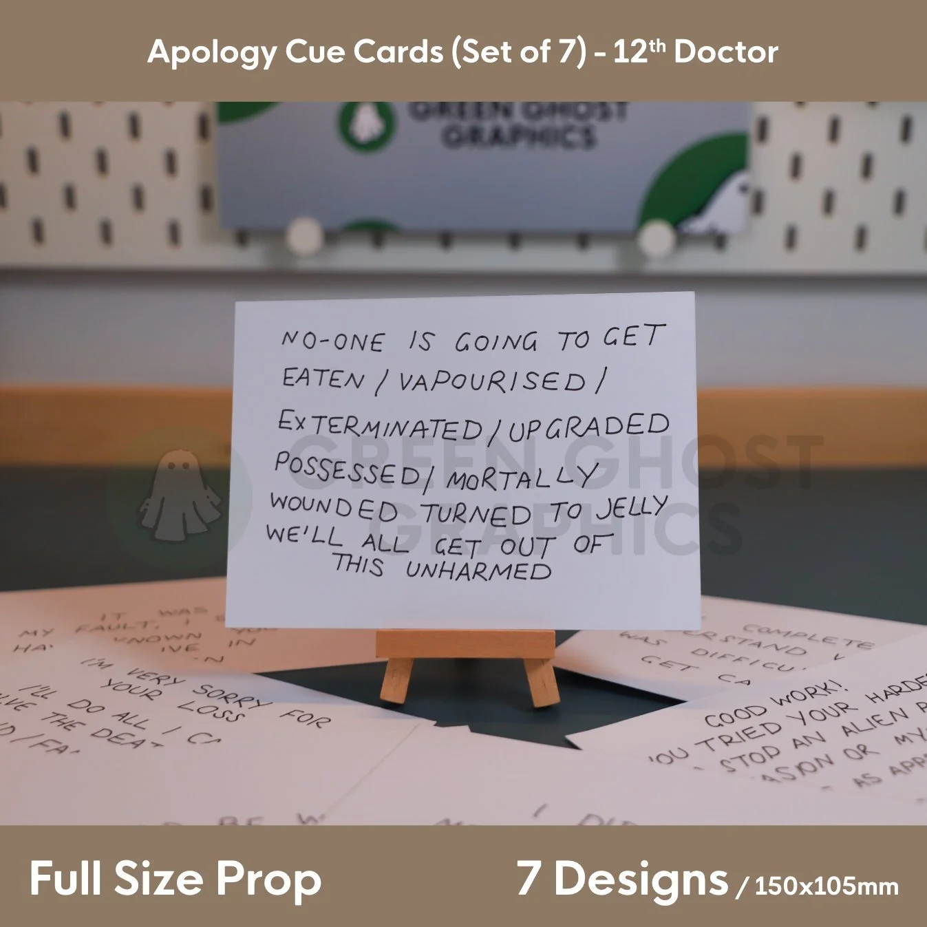 A white apology card with text beginning “NO-ONE IS GOING TO GET EATEN” shown upright on a wooden easel with matching cards spread across the surface below.