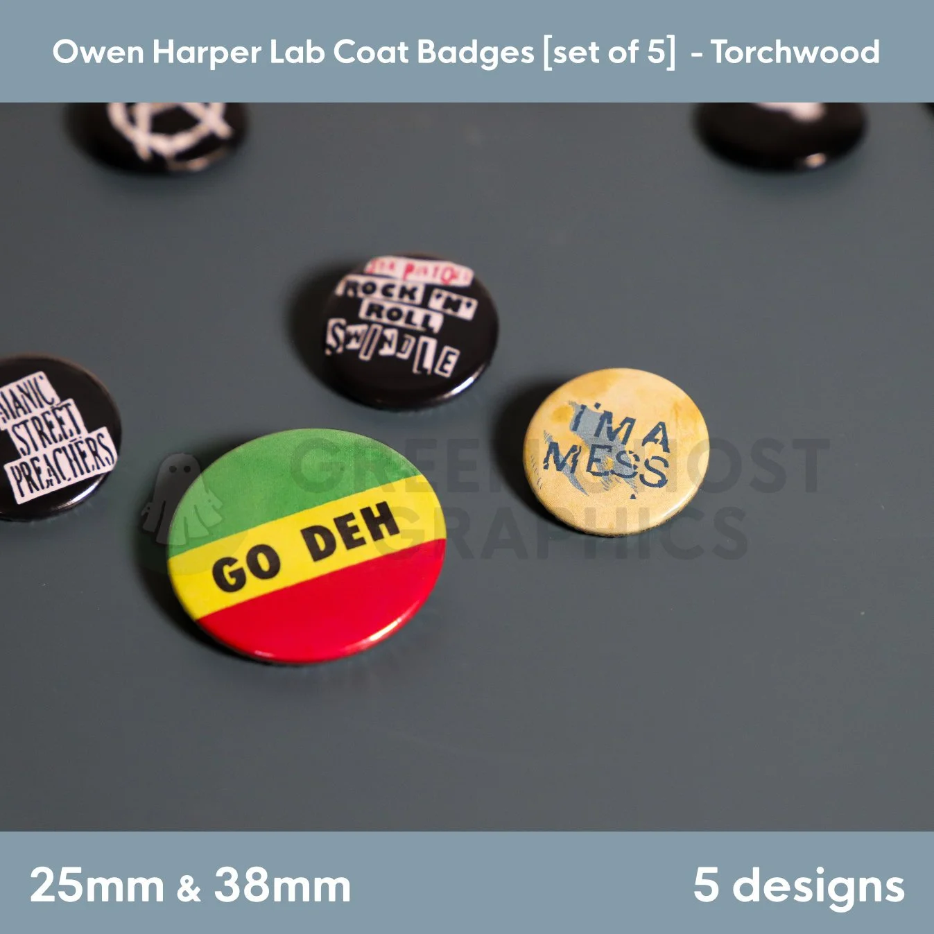 Three circular badges featuring the texts “GO DEH,” “I'M A MESS,” and “ROCK ’N’ ROLL SWINDLE” arranged side by side on a tabletop.