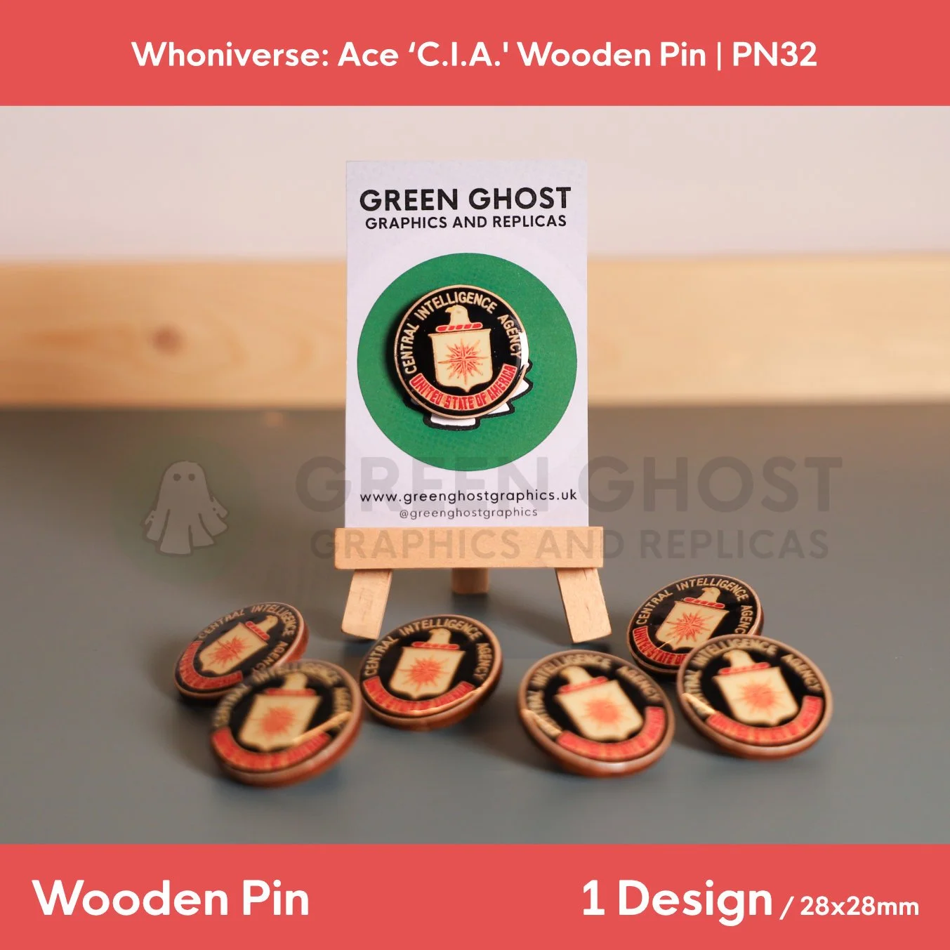 A circular wooden pin with a black background and a coloured motif and text, “Central Intelligence Agency, United States of America” displayed on a branded backing card with several identical pins.