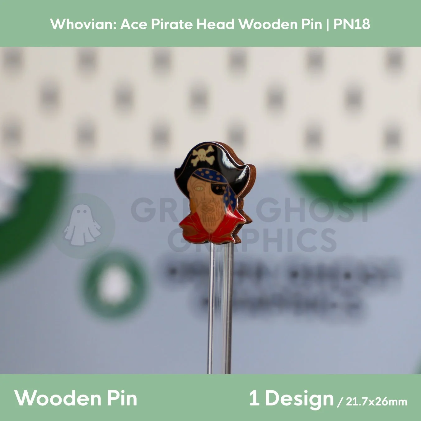 A colourful pirate‑head wooden pin featuring a black hat with a skull motif and red clothing shown at an angle on a clear display stand.