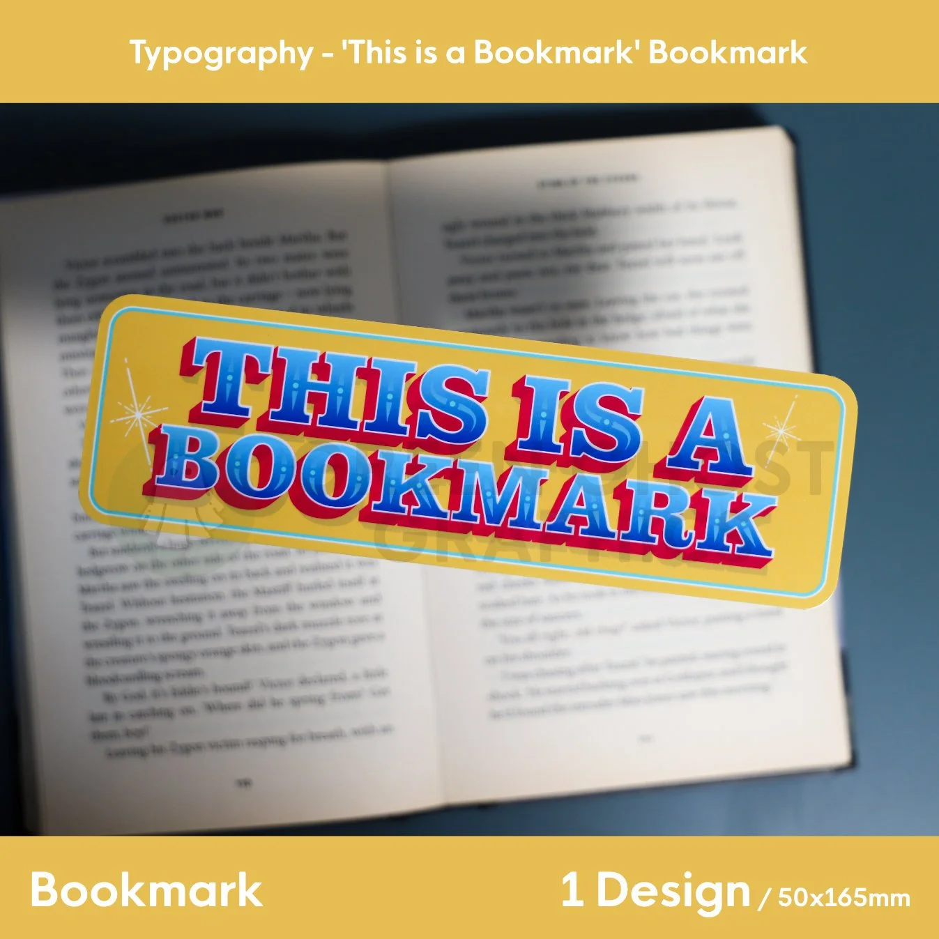 A white bookmark featuring ghost illustrations and the words “GREEN GHOST GRAPHICS” held in a blue binder clip with other yellow bookmarks visible behind.