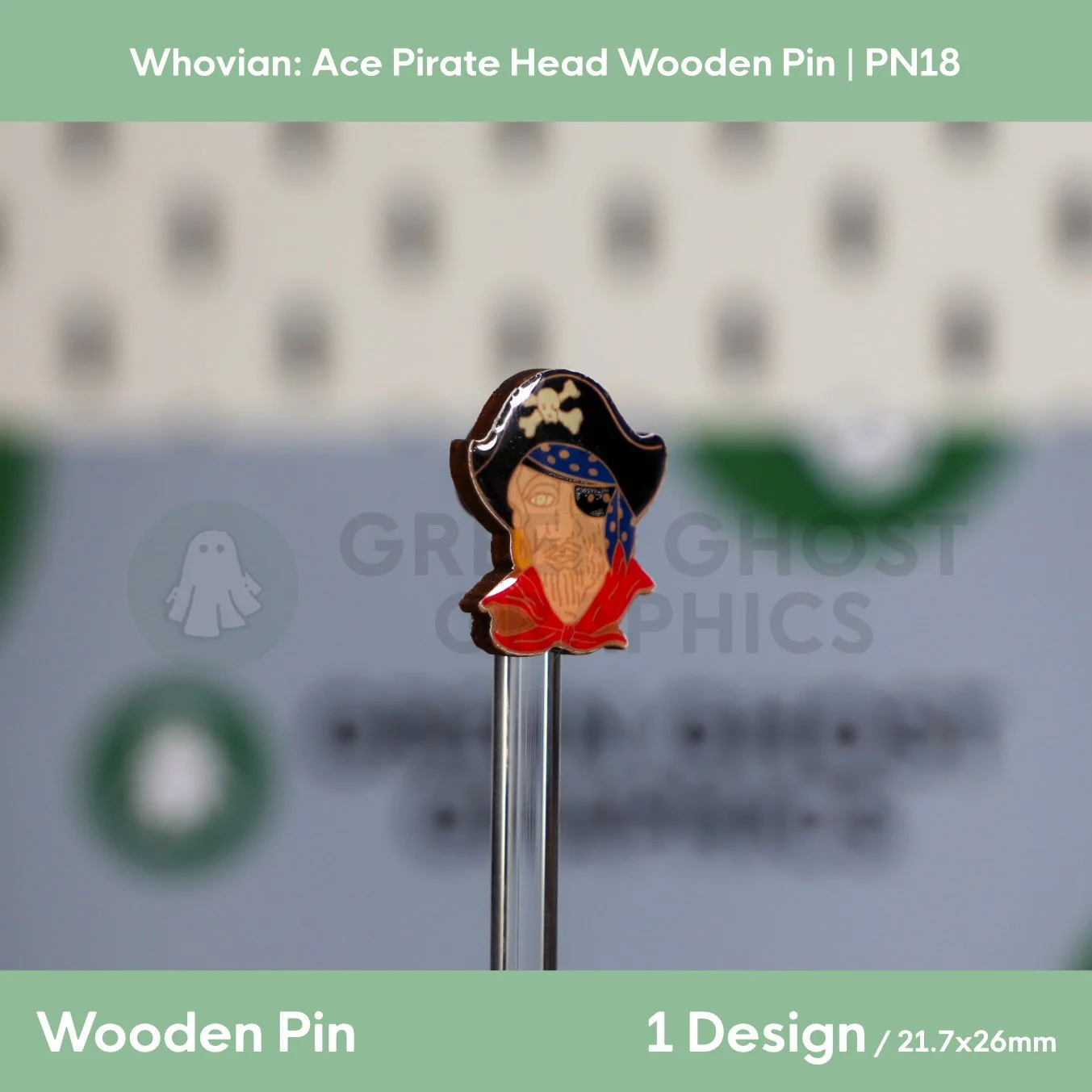 A shaped wooden pin depicting a pirate with a black hat, skull emblem, blue bandana, eye patch, and red coat displayed upright on a transparent rod.