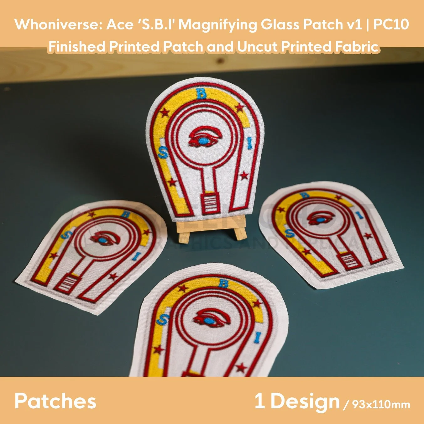 Printed patch design, finished with interfacing and glued edges. Horse shoe and magnifying glass design in red, with blue and red text and detailing including a red and blue eye.