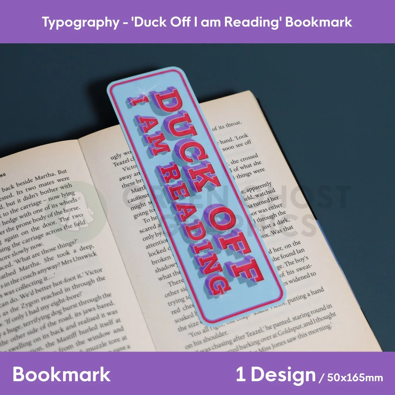 A blue bookmark bordered in red with bold “DUCK OFF I AM READING” typography placed flat across an open book.